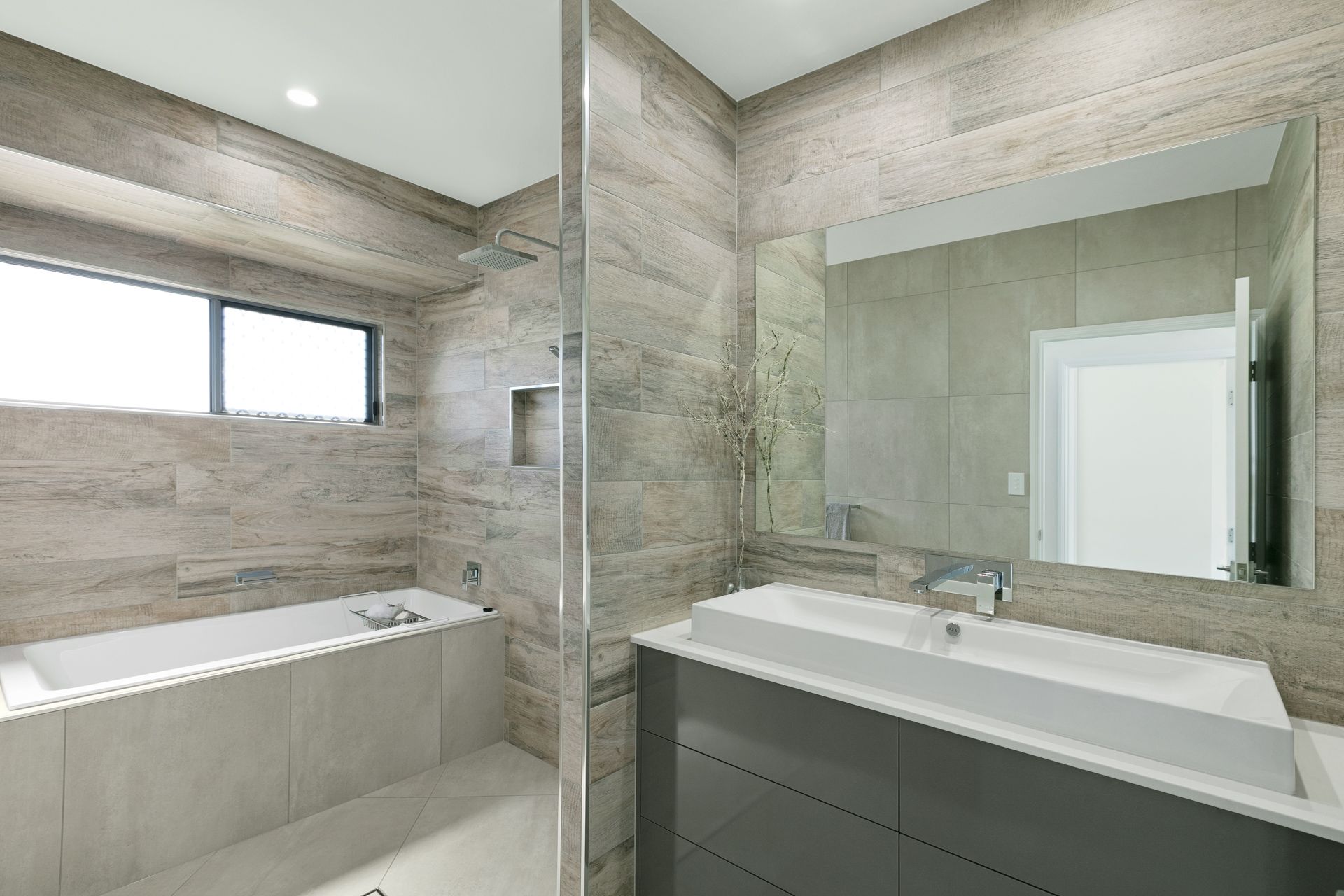 A Modern Bathroom With a Bathtub, Glass Shower Screen — Ashlee Jones Homes in Gordonvale, QLD