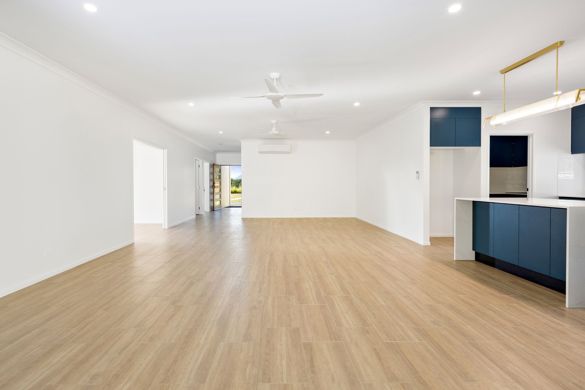 An Empty, Bright Room With Light Wood Flooring — Ashlee Jones Homes in Gordonvale, QLD