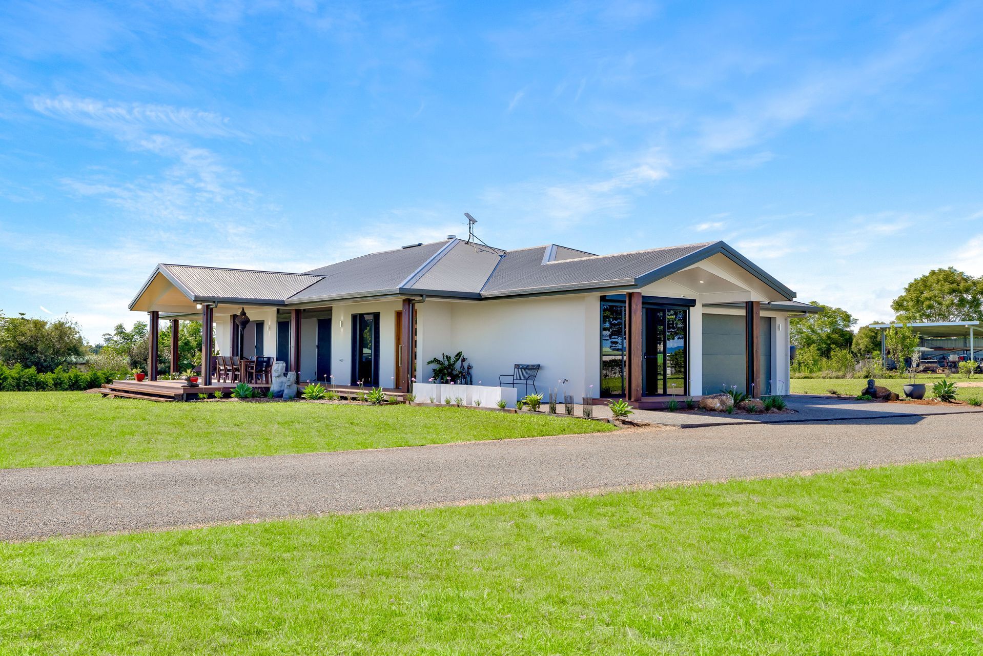 A Single-story White House With a Dark Roof and Wooden Accents — Ashlee Jones Homes in Gordonvale, QLD