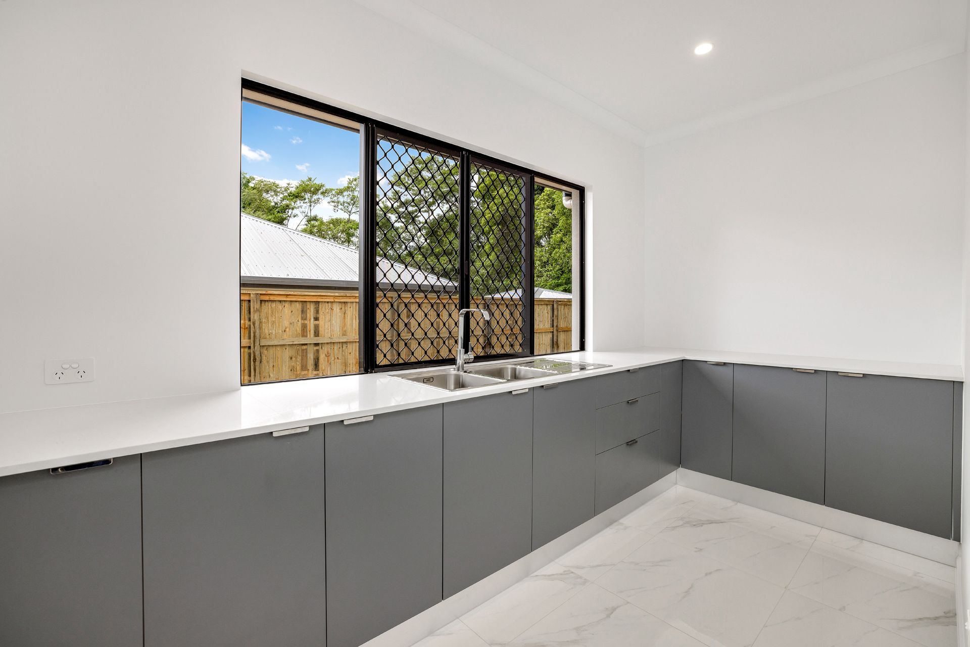 A Modern Kitchen Featuring Matte Grey Cabinets — Ashlee Jones Homes in Gordonvale, QLD