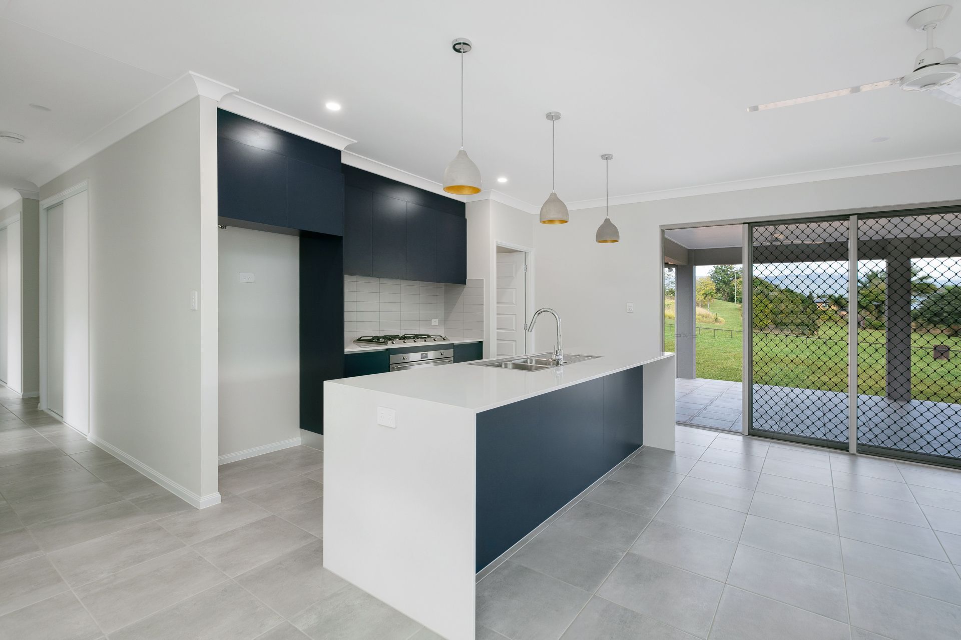 Modern Kitchen With a White Quartz Island, Dark Navy Cabinetry — Ashlee Jones Homes in Gordonvale, QLD