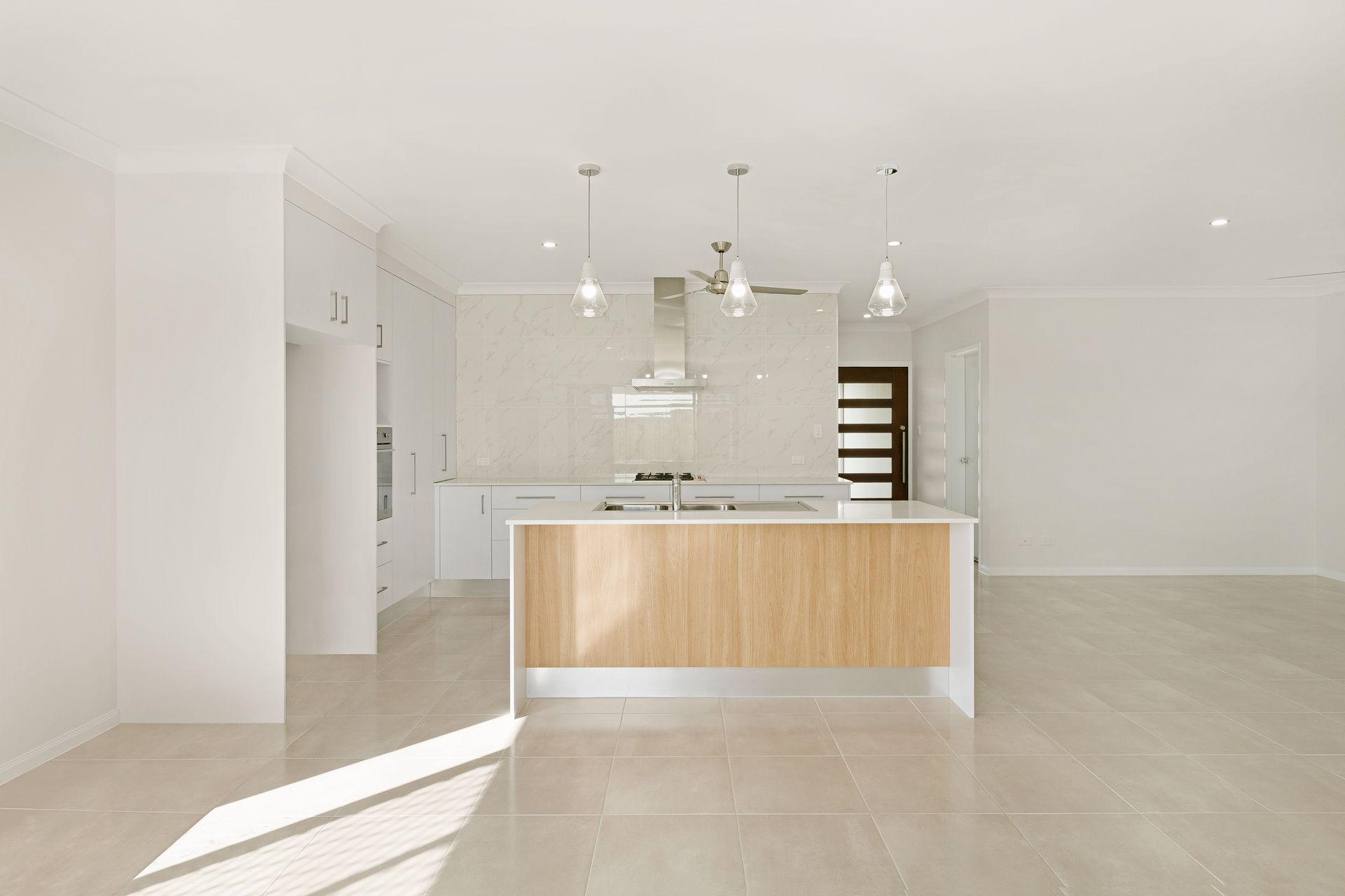 A Bright, Modern Kitchen With White Cabinets — Ashlee Jones Homes in Gordonvale, QLD