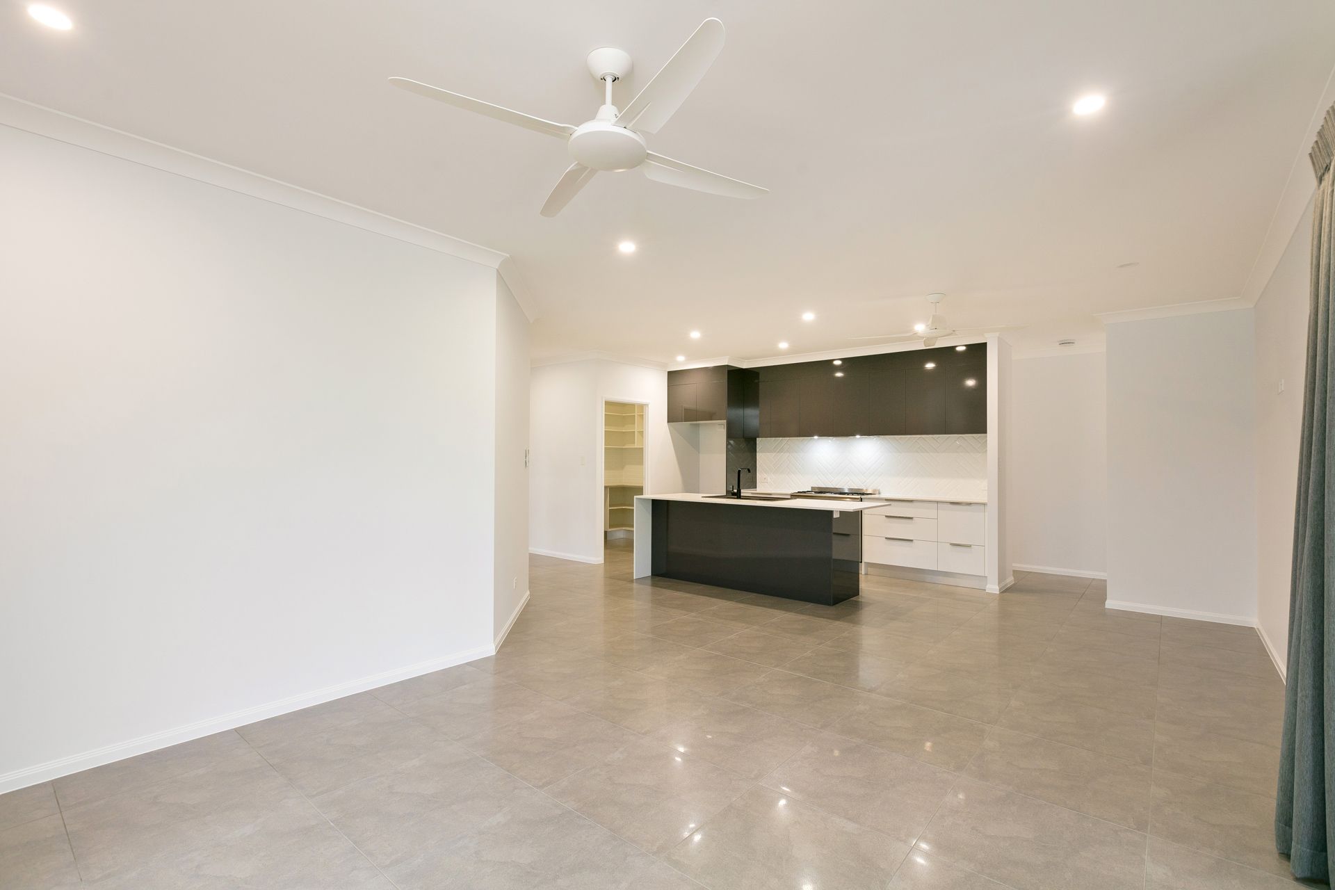 An Open-plan Living Room With Light Grey Tile Floors — Ashlee Jones Homes in Gordonvale, QLD