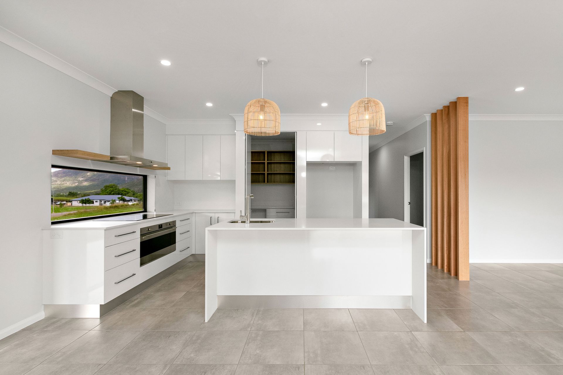 A Modern Kitchen With White Cabinets, a Central Island — Ashlee Jones Homes in Gordonvale, QLD