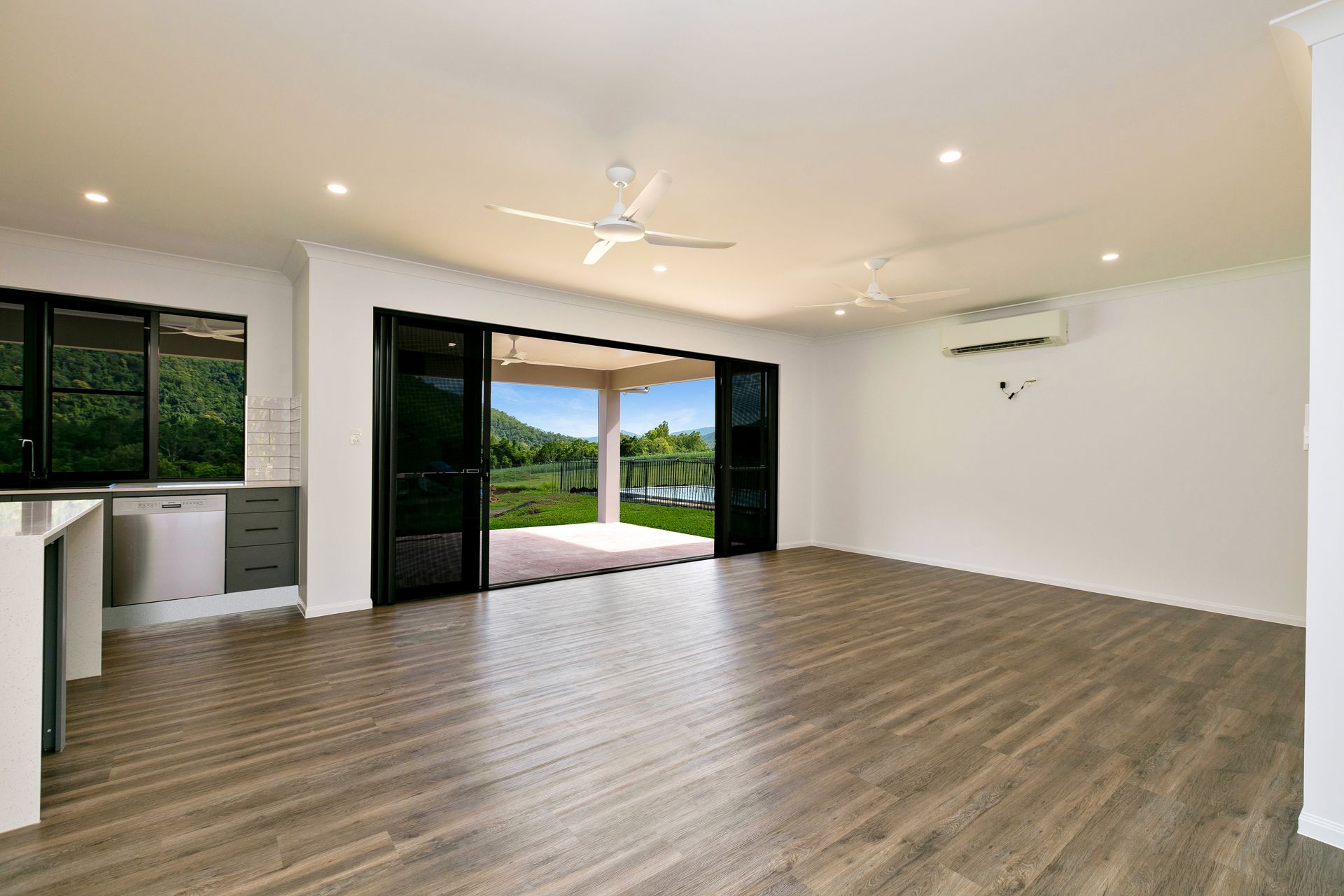 An Open-plan Living Room With Wood Flooring — Ashlee Jones Homes in Gordonvale, QLD