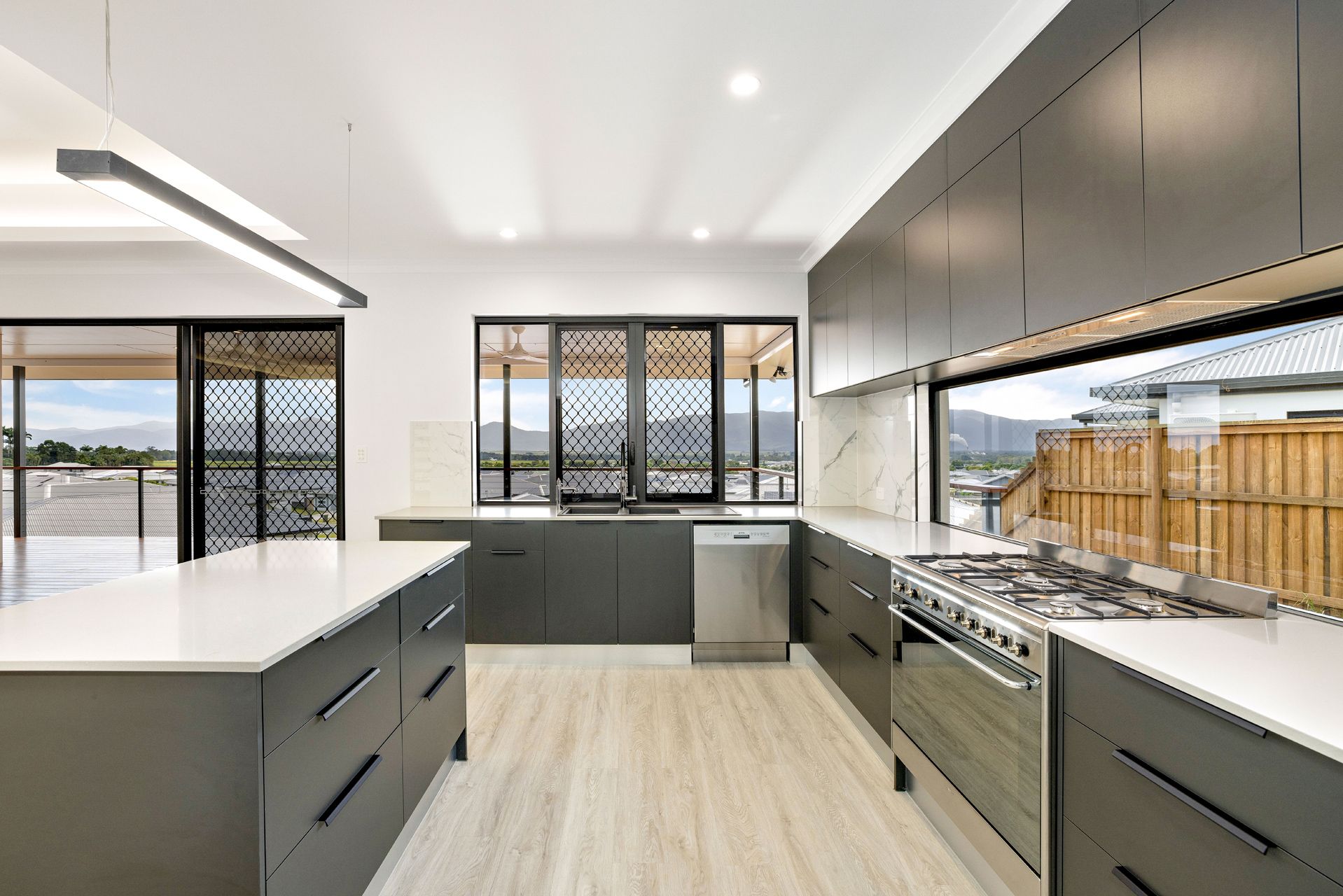 Modern Kitchen With Dark Grey Cabinetry, White Countertops — Ashlee Jones Homes in Gordonvale, QLD