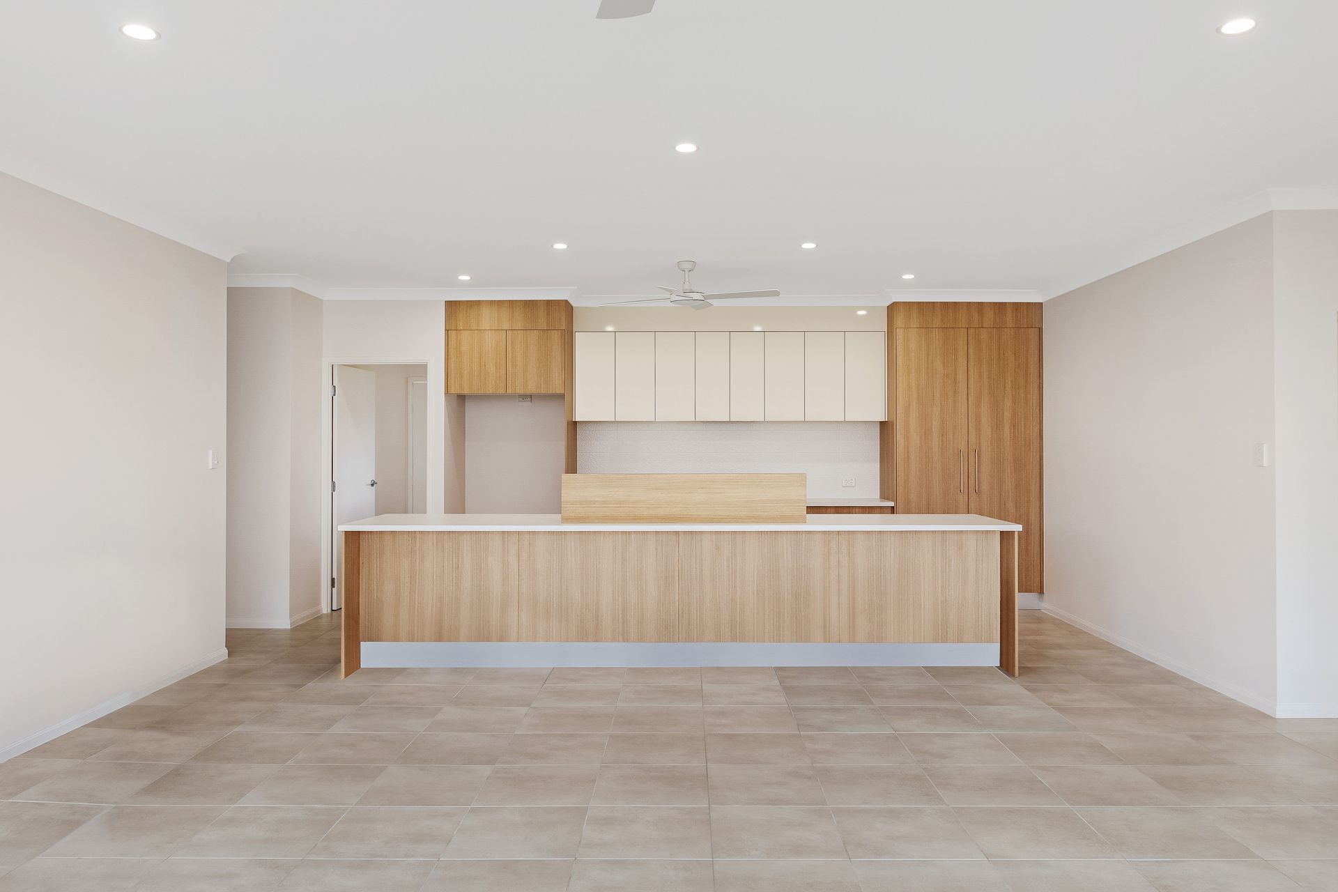 A Modern Kitchen With Light Wood Cabinetry — Ashlee Jones Homes in Gordonvale, QLD