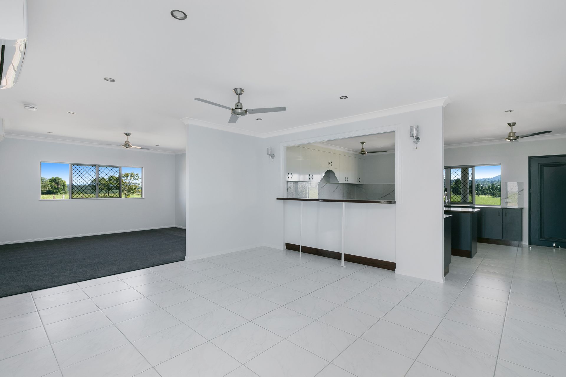 A Brightly Lit, Open-plan Room With White Tiled Floors — Ashlee Jones Homes in Gordonvale, QLD