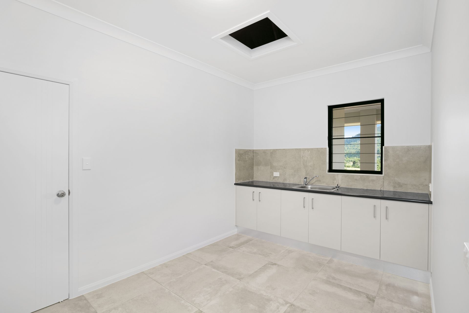 A Small, Bright Room With White Walls, Light Tile Flooring — Ashlee Jones Homes in Gordonvale, QLD
