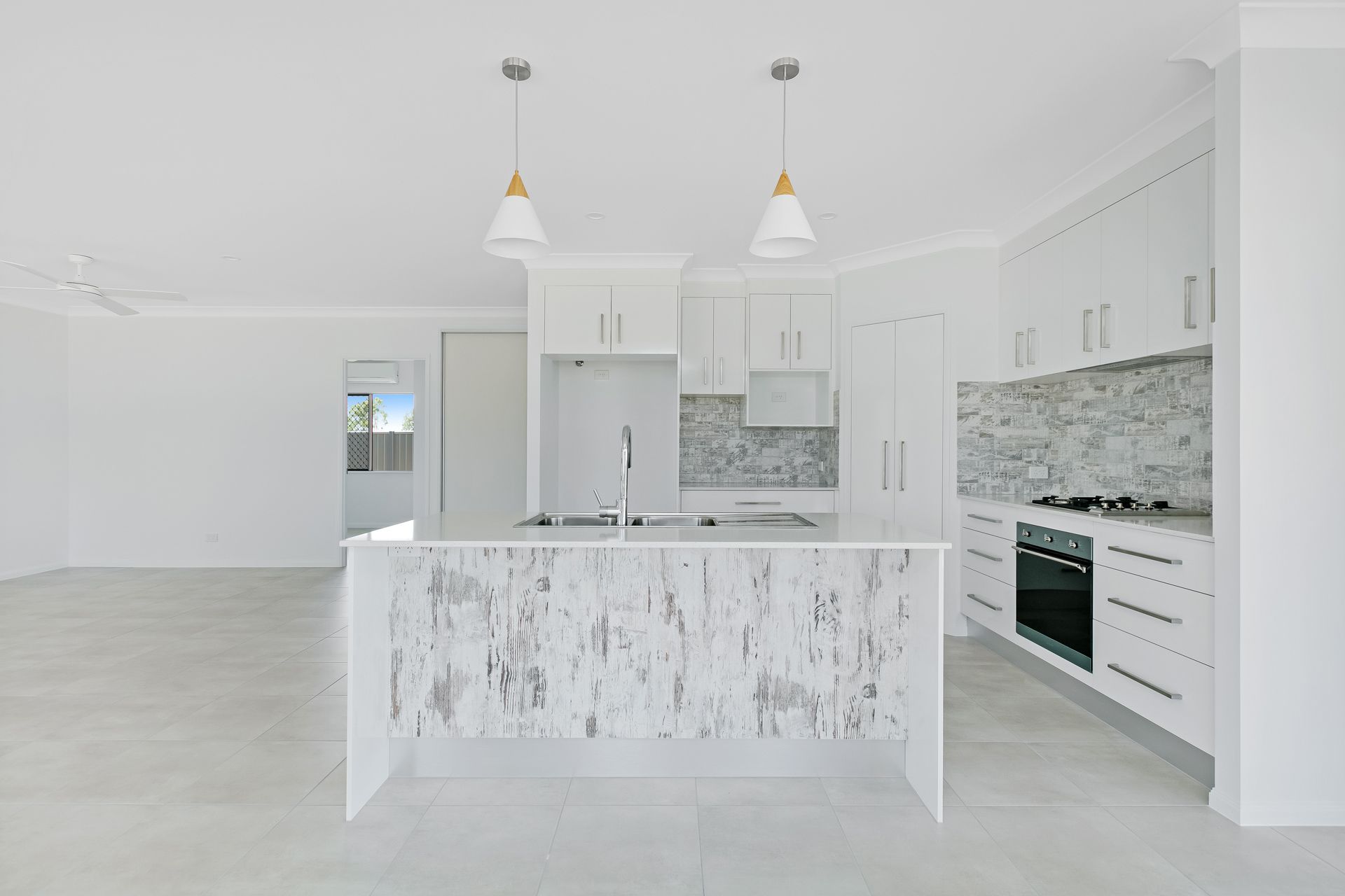 A Modern, All-white Kitchen Featuring a Marble-patterned Island — Ashlee Jones Homes in Gordonvale, QLD