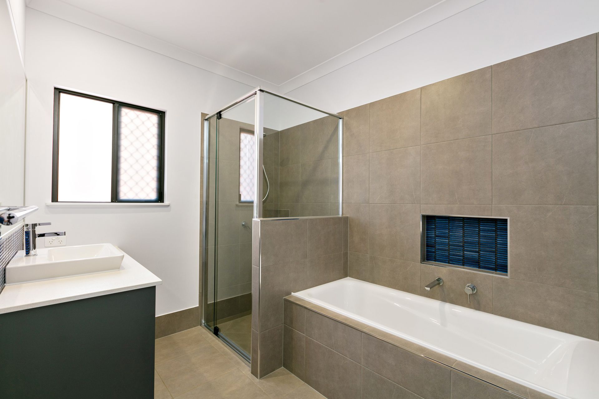 A Modern Bathroom Featuring a White Vanity — Ashlee Jones Homes in Gordonvale, QLD