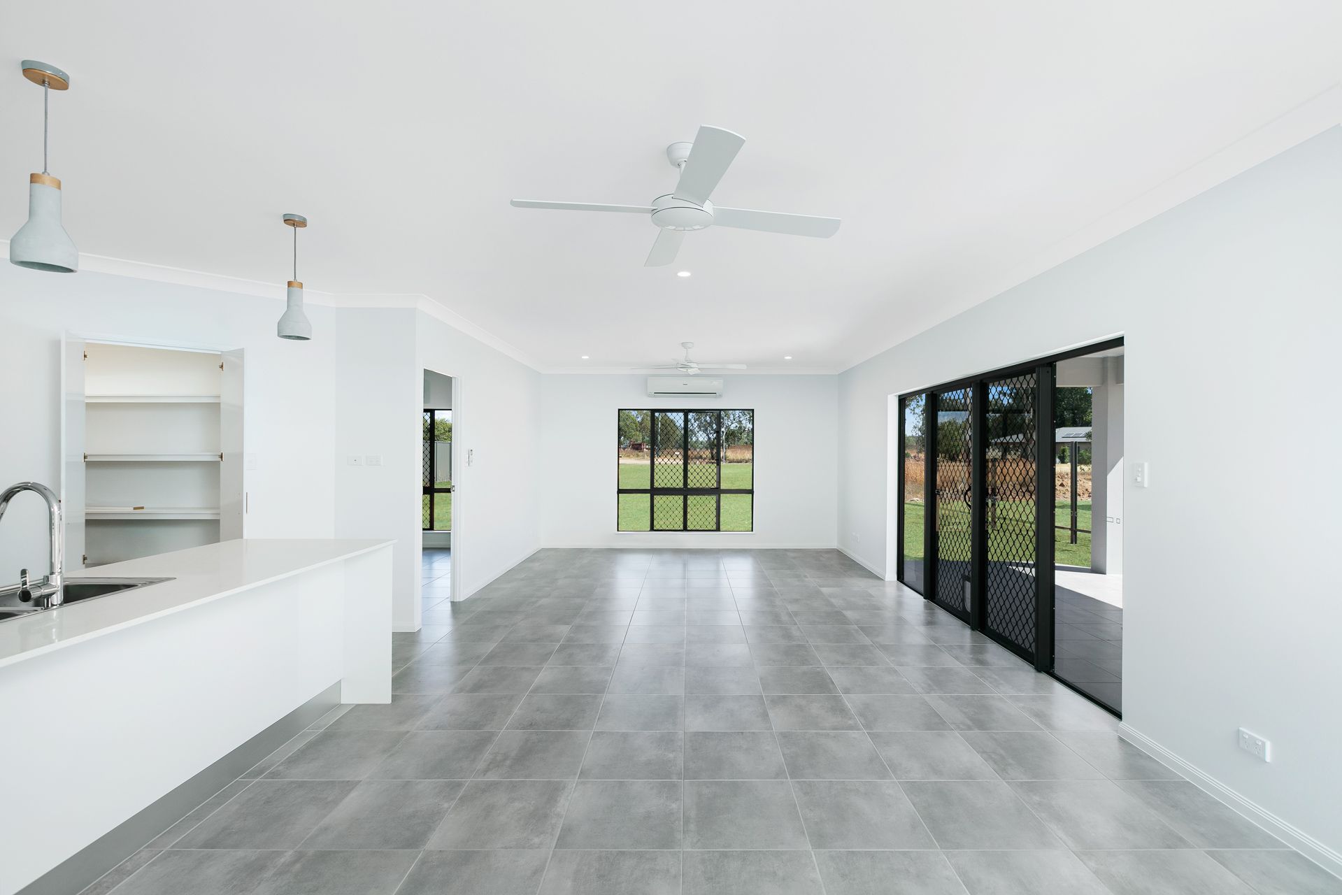 A Modern, Open-plan Living Area With White Walls — Ashlee Jones Homes in Gordonvale, QLD