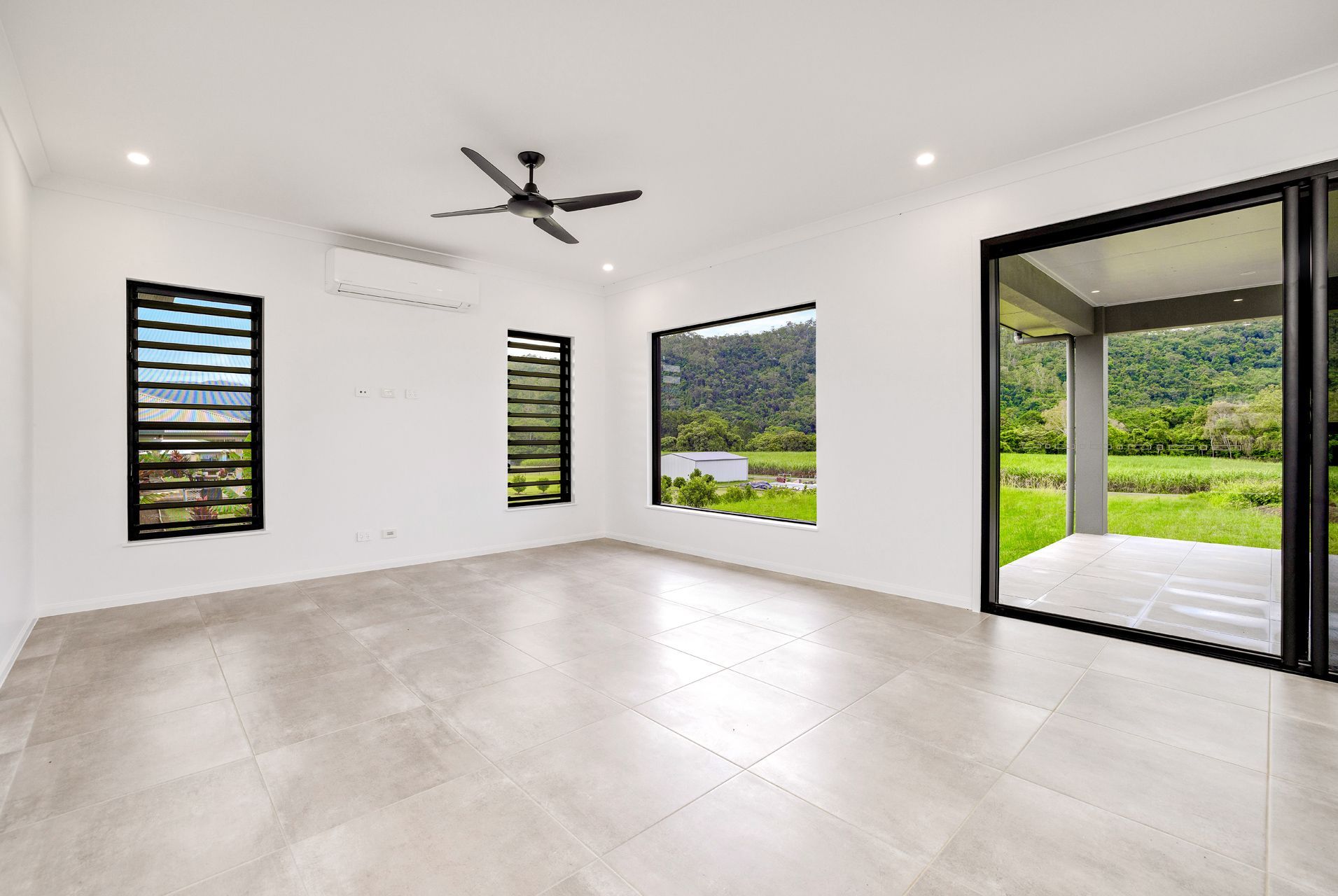 An Empty Room With White Walls, Light Tile Floors — Ashlee Jones Homes in Gordonvale, QLD
