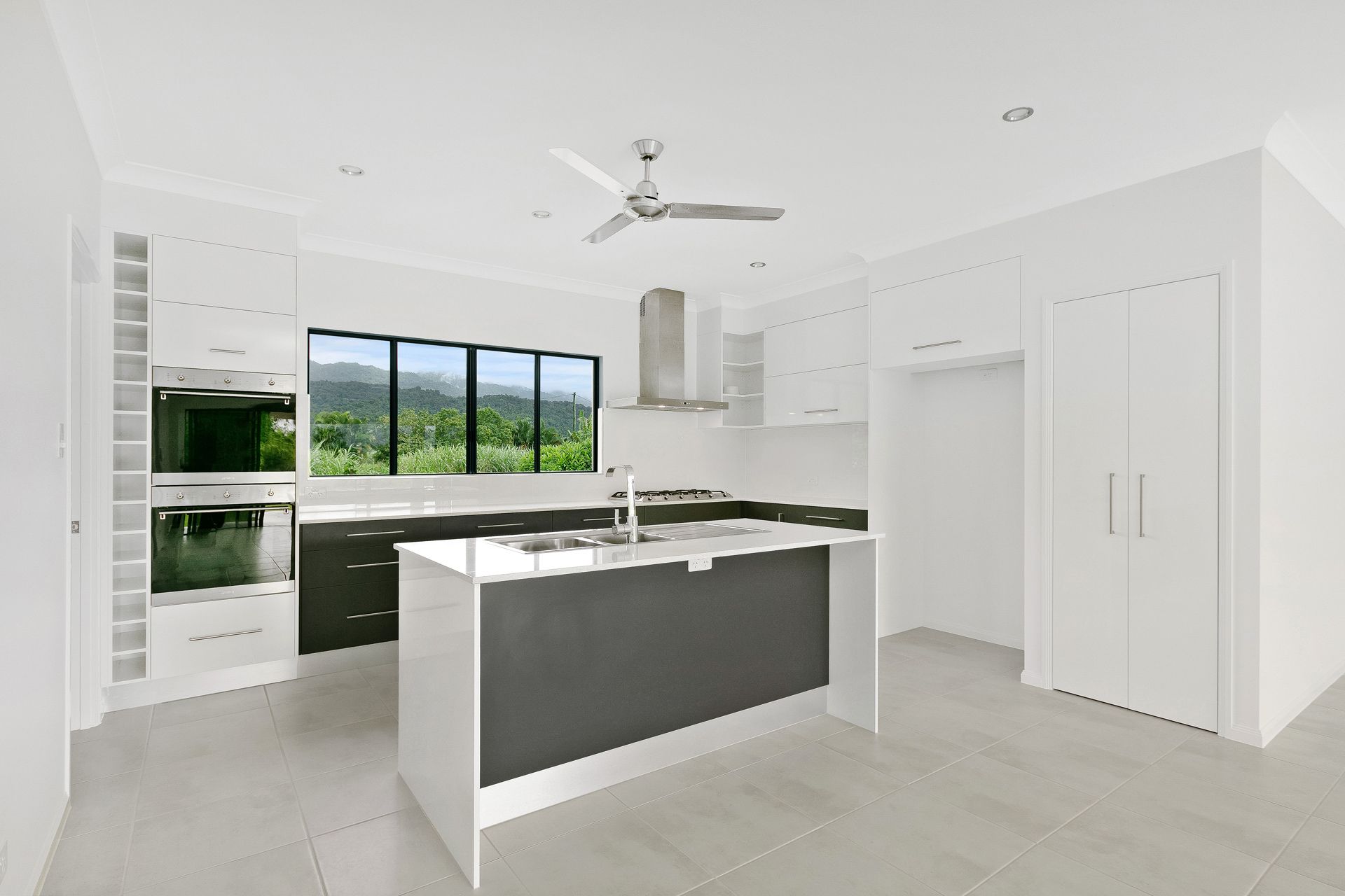 A Bright, Modern Kitchen With White Cabinetry — Ashlee Jones Homes in Gordonvale, QLD