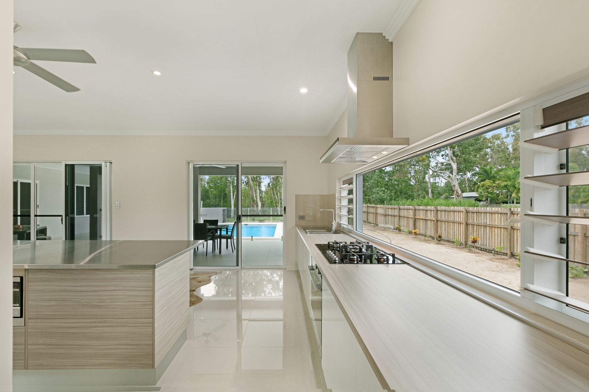 A Bright, Modern Kitchen With Light Wood Cabinets — Ashlee Jones Homes in Gordonvale, QLD