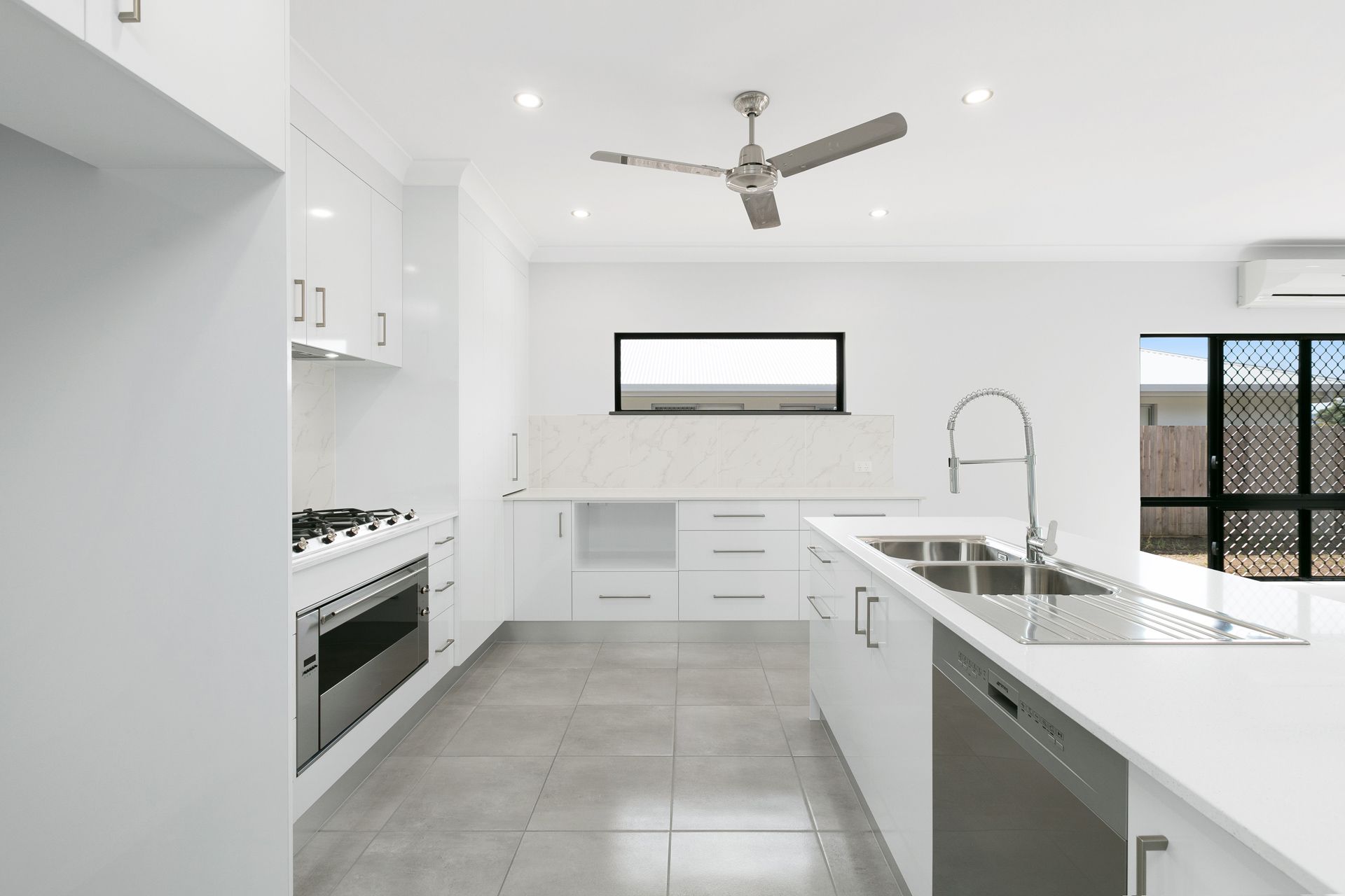 A Bright, Modern Kitchen Featuring White Cabinetry — Ashlee Jones Homes in Gordonvale, QLD