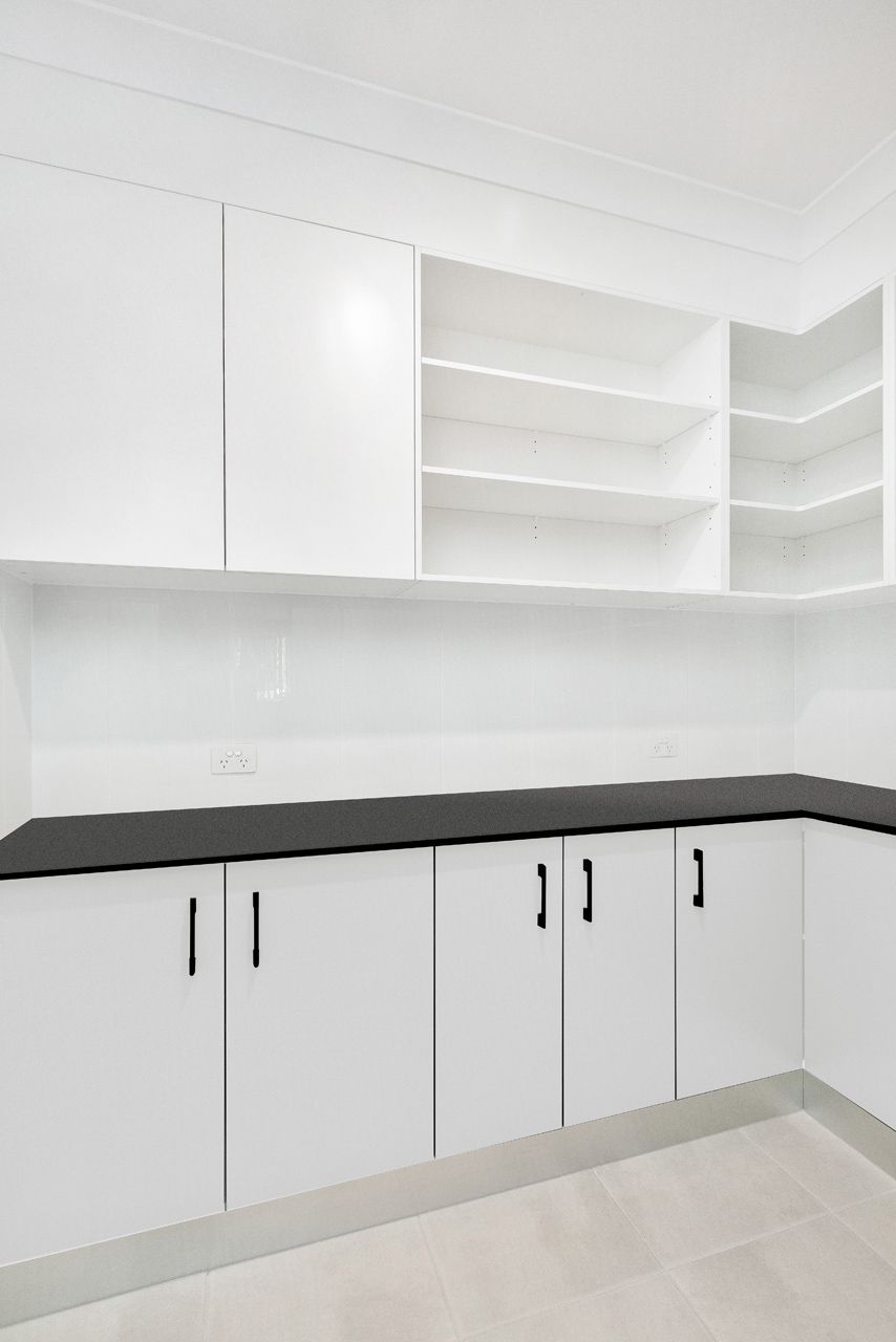 A Modern Kitchen Corner With White Cabinets — Ashlee Jones Homes in Gordonvale, QLD