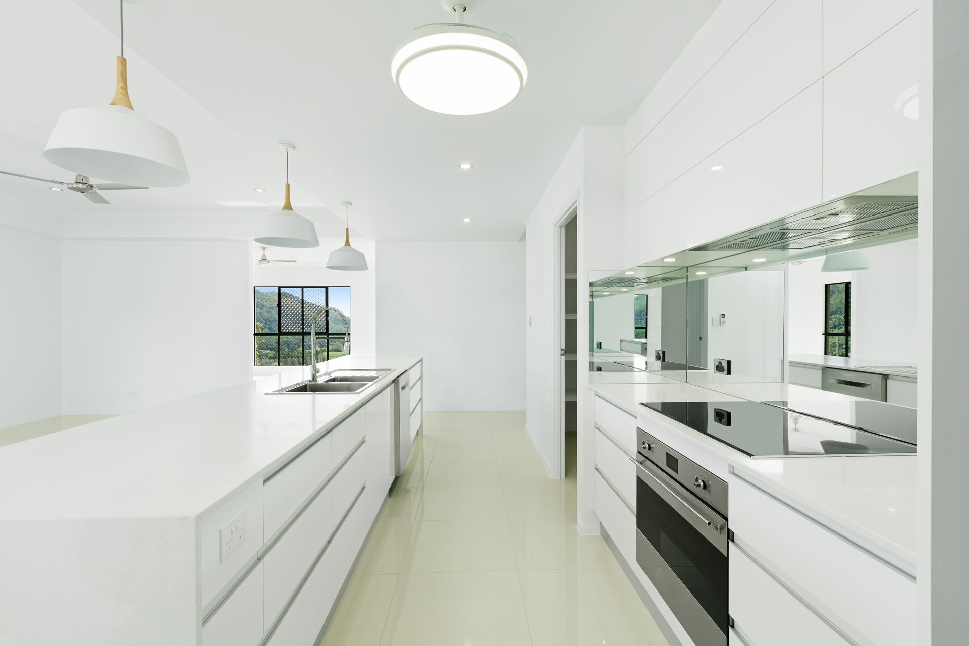 A Bright, Modern Kitchen Featuring White Cabinetry — Ashlee Jones Homes in Gordonvale, QLD