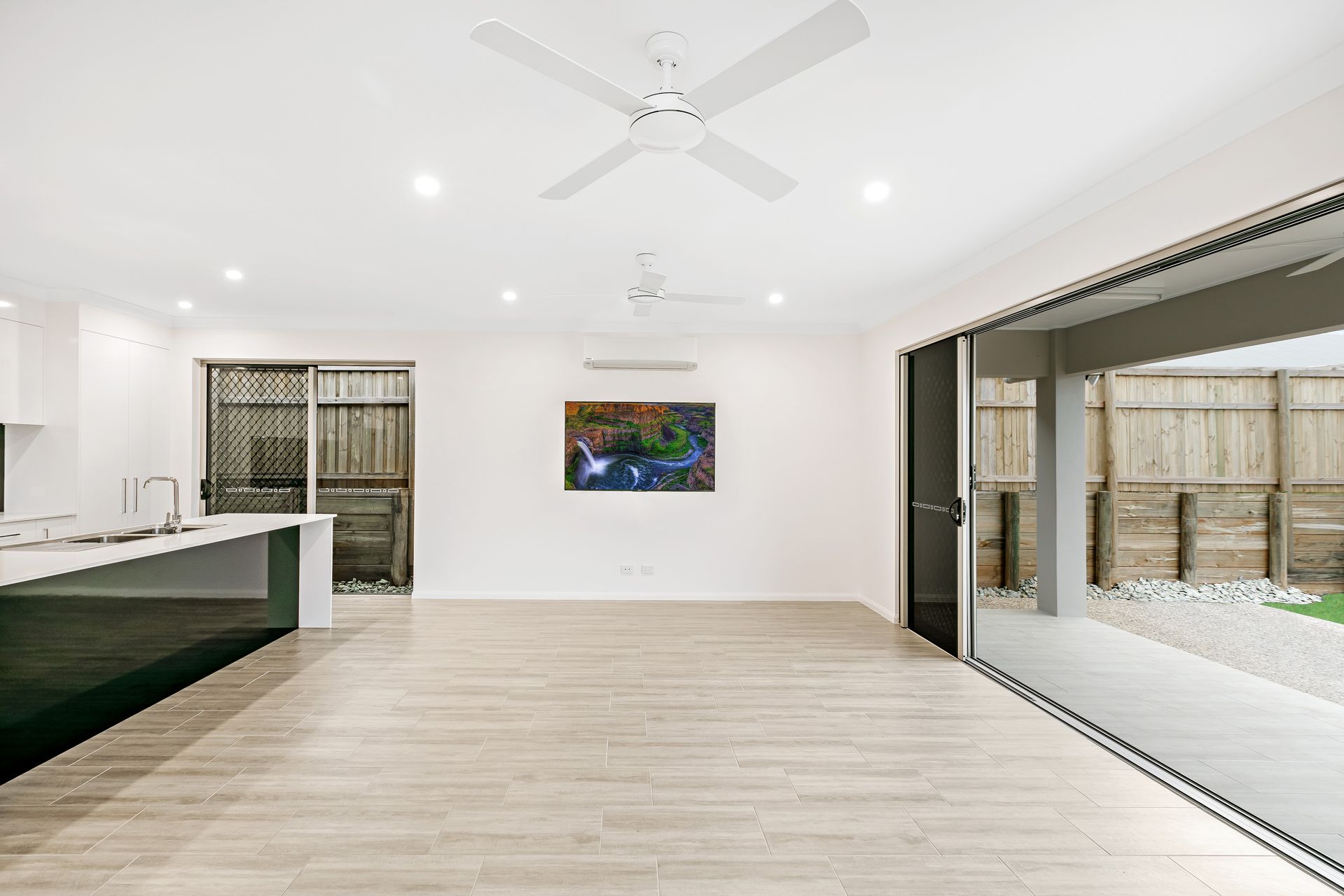 Modern Living Area With Wood-look Tile Floors, a White Kitchen Island — Ashlee Jones Homes in Gordonvale, QLD