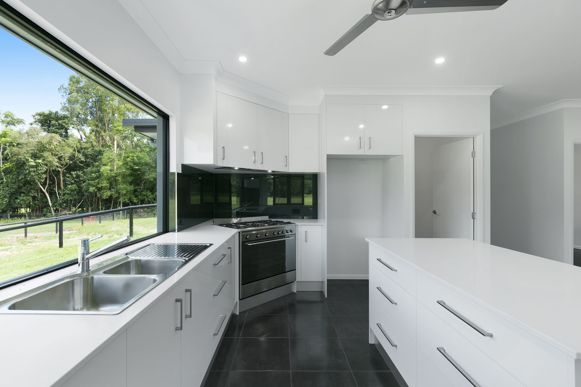 A Modern, Minimalist Kitchen With White Cabinets — Ashlee Jones Homes in Gordonvale, QLD