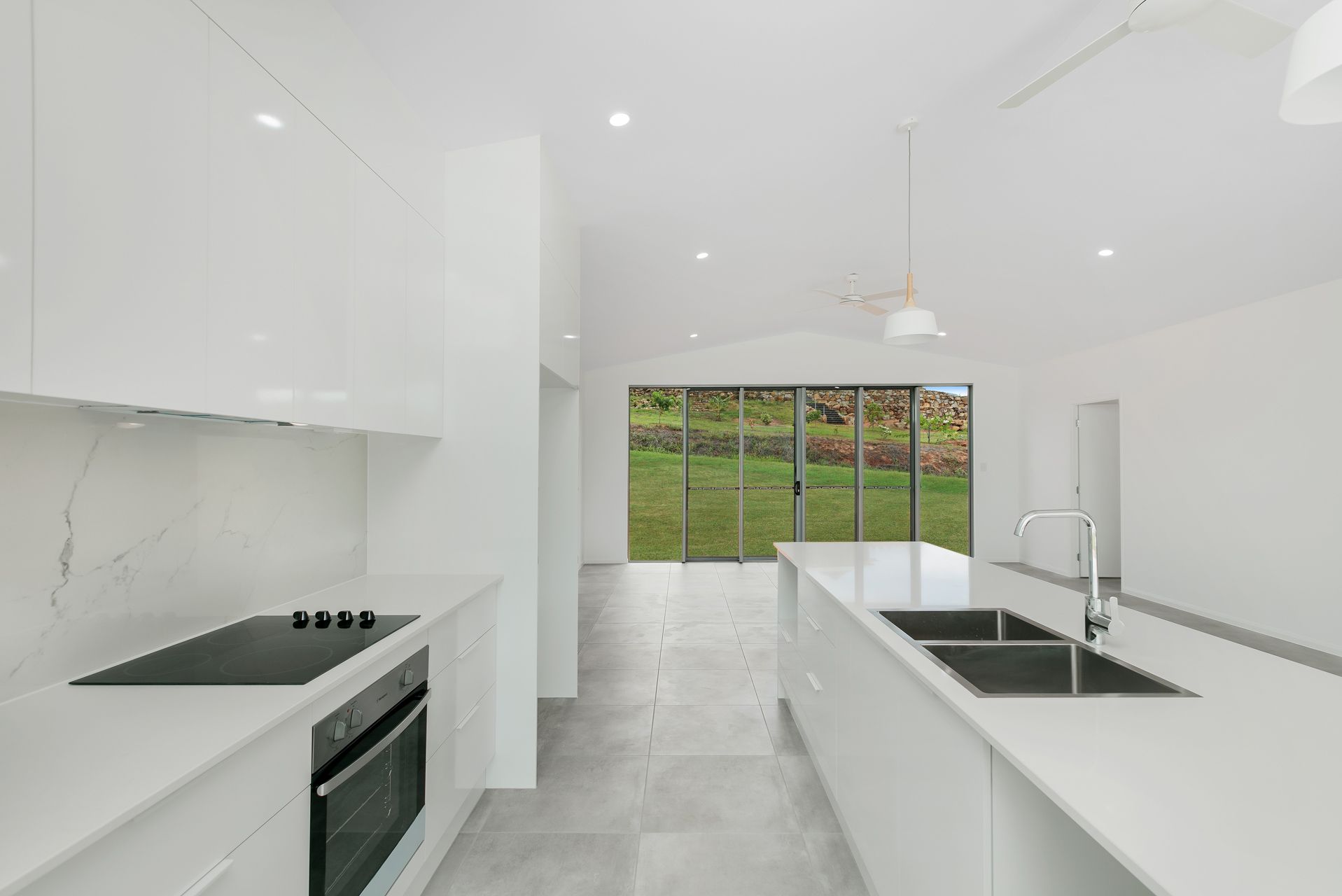 A Bright, Modern Kitchen With White Cabinetry — Ashlee Jones Homes in Gordonvale, QLD