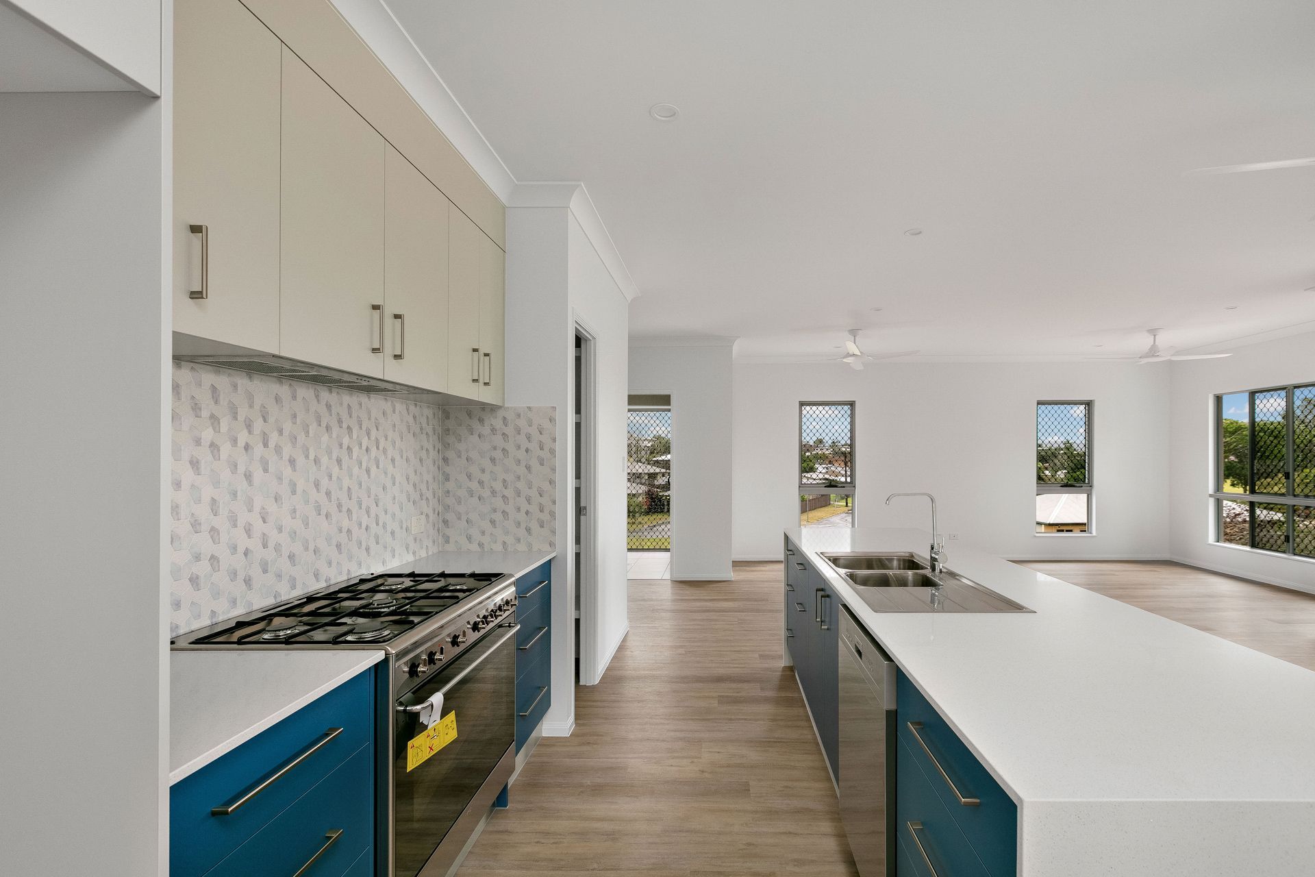 A Modern Kitchen Featuring Blue Lower Cabinets — Ashlee Jones Homes in Gordonvale, QLD