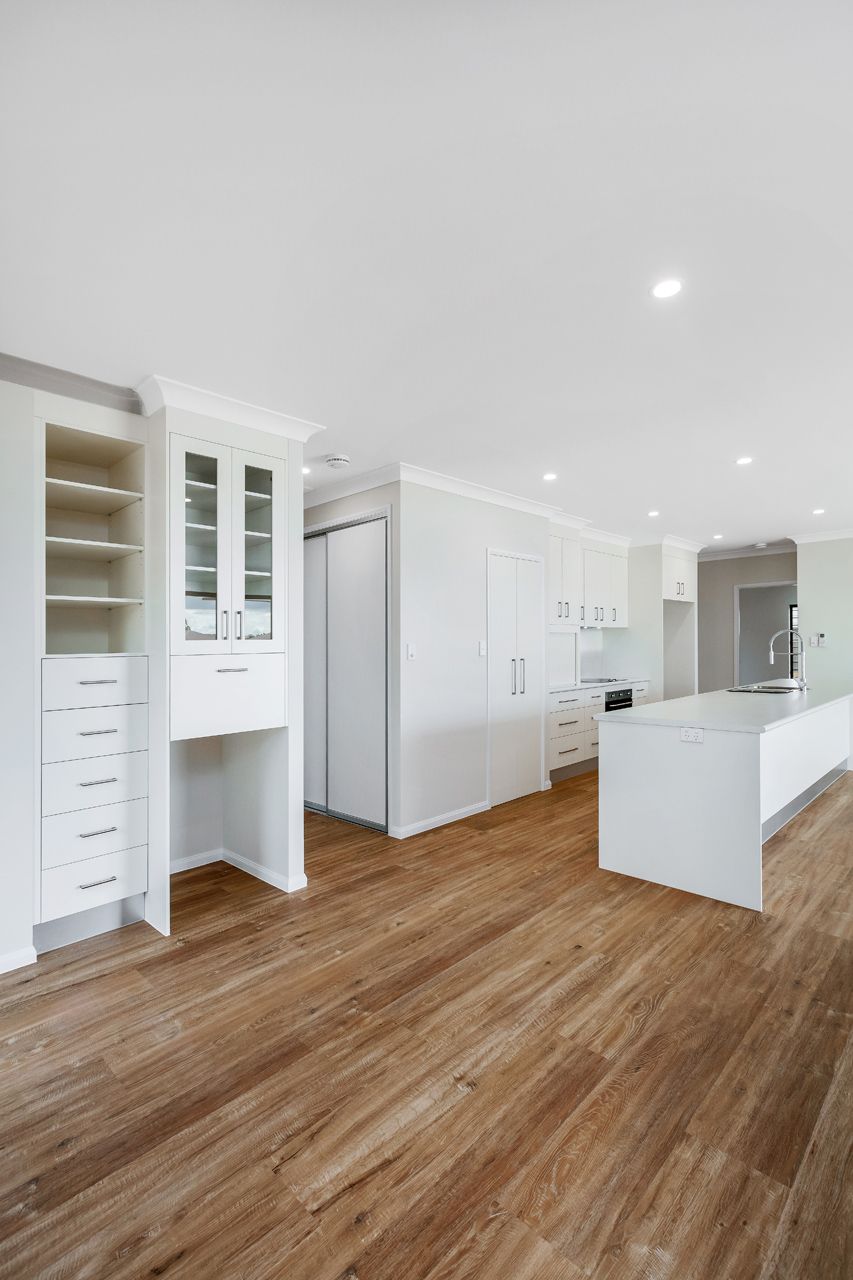 A Modern, Open-plan Kitchen Featuring White Cabinetry — Ashlee Jones Homes in Gordonvale, QLD