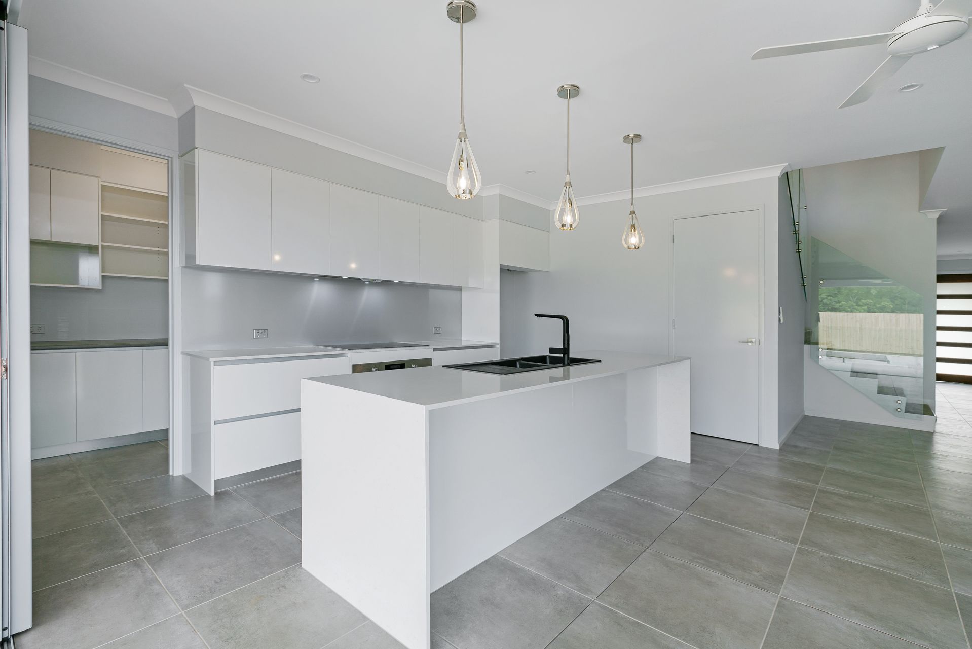 A Minimalist, Modern Kitchen With White Cabinetry — Ashlee Jones Homes in Gordonvale, QLD