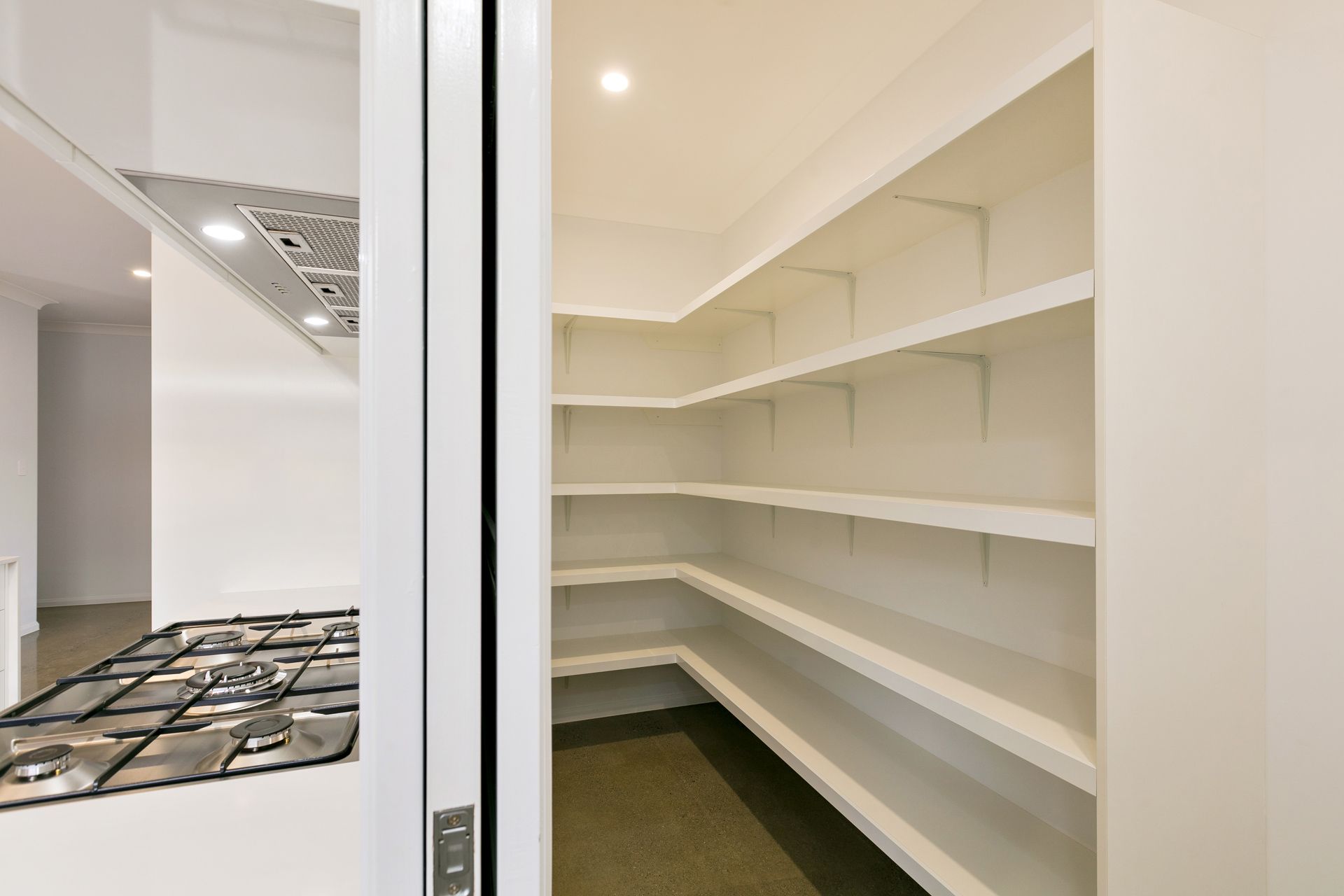 A Walk-in Pantry Featuring White L-shaped Shelves — Ashlee Jones Homes in Gordonvale, QLD
