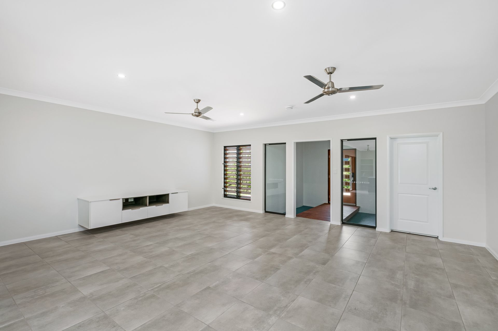 Spacious Living Room With Light Gray Tile Flooring — Ashlee Jones Homes in Gordonvale, QLD