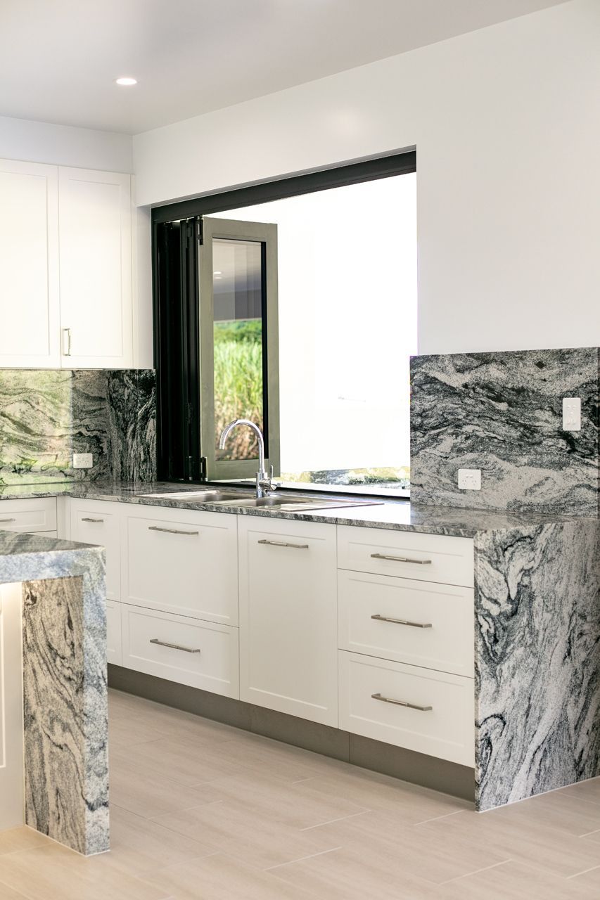 A Modern Kitchen With White Cabinetry — Ashlee Jones Homes in Gordonvale, QLD
