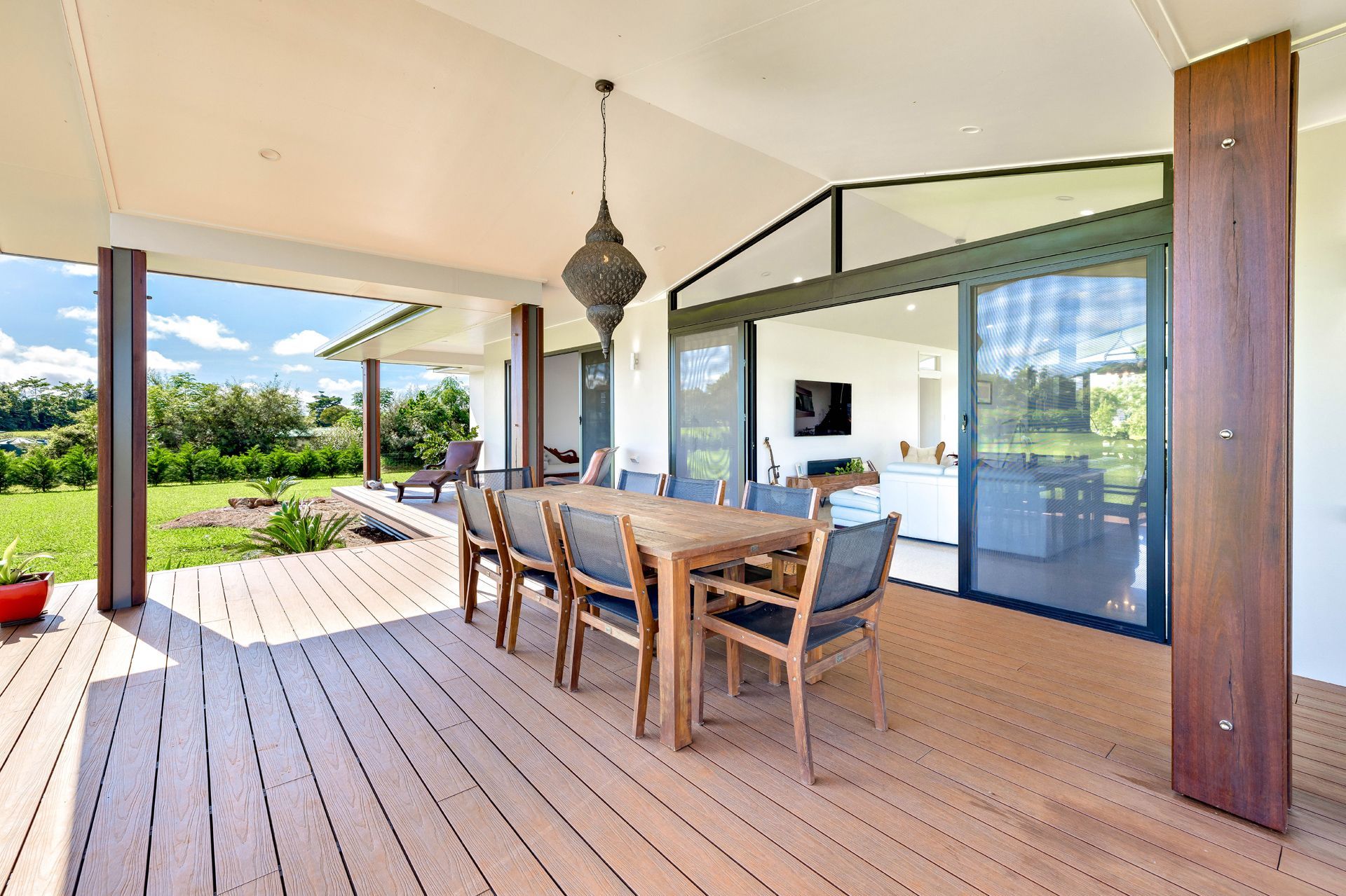 A Wooden Deck With an Outdoor Dining Set Under a Covered Patio — Ashlee Jones Homes in Gordonvale, QLD