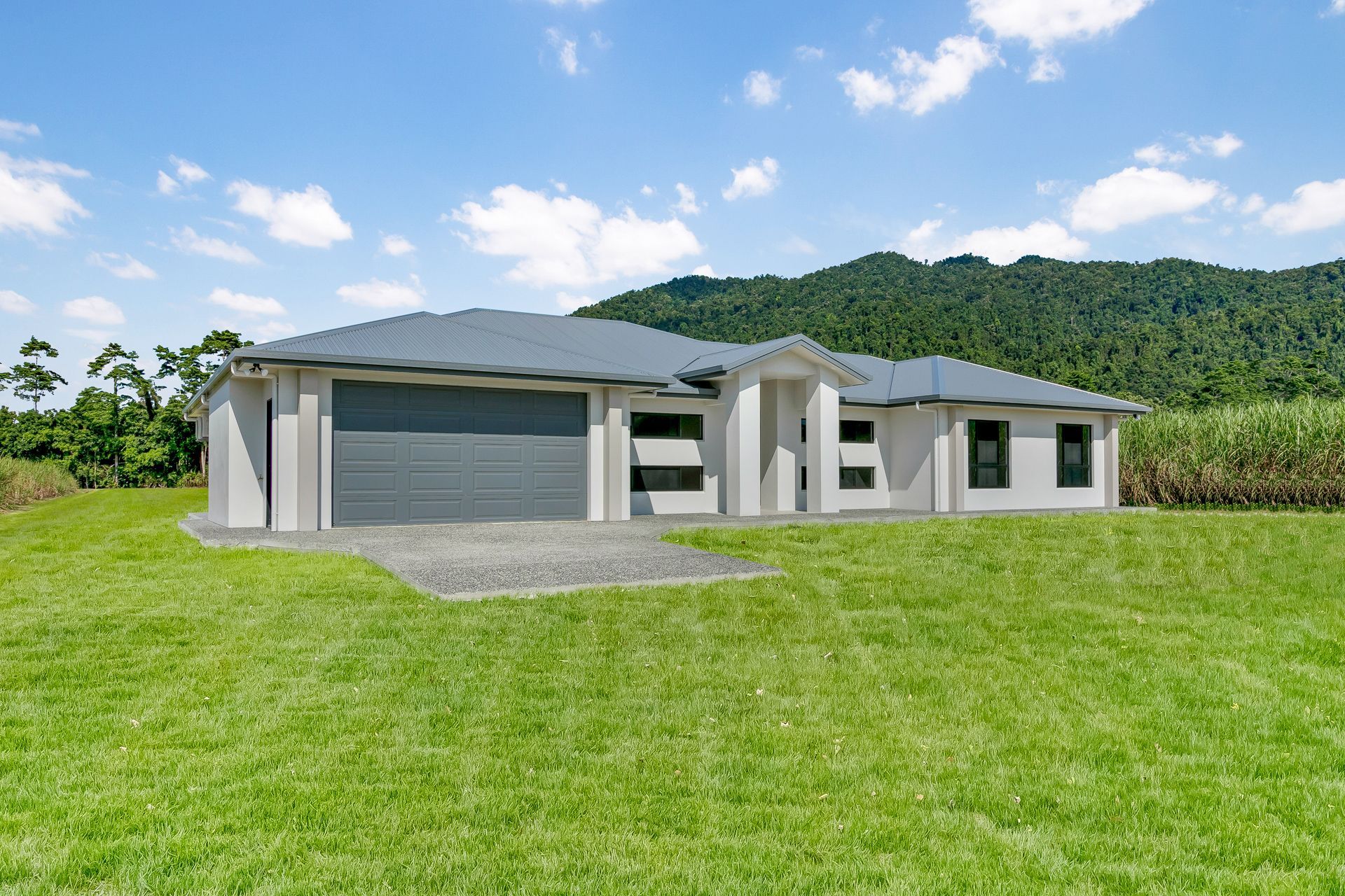 A Modern, Single-story Light-colored House With a Dark Roof — Ashlee Jones Homes in Gordonvale, QLD