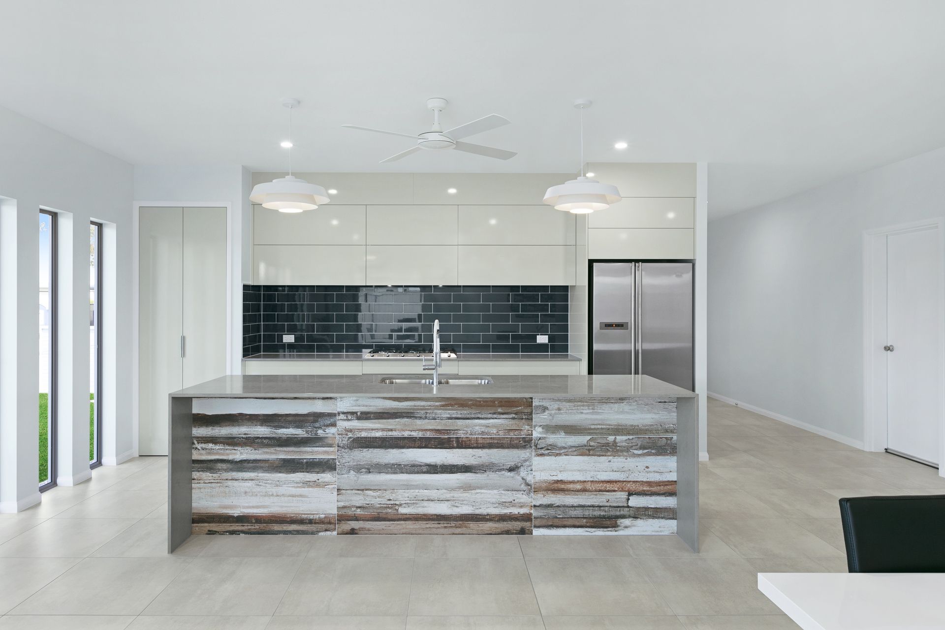 Modern Kitchen Featuring a Large Island With Weathered Wood Panels — Ashlee Jones Homes in Gordonvale, QLD