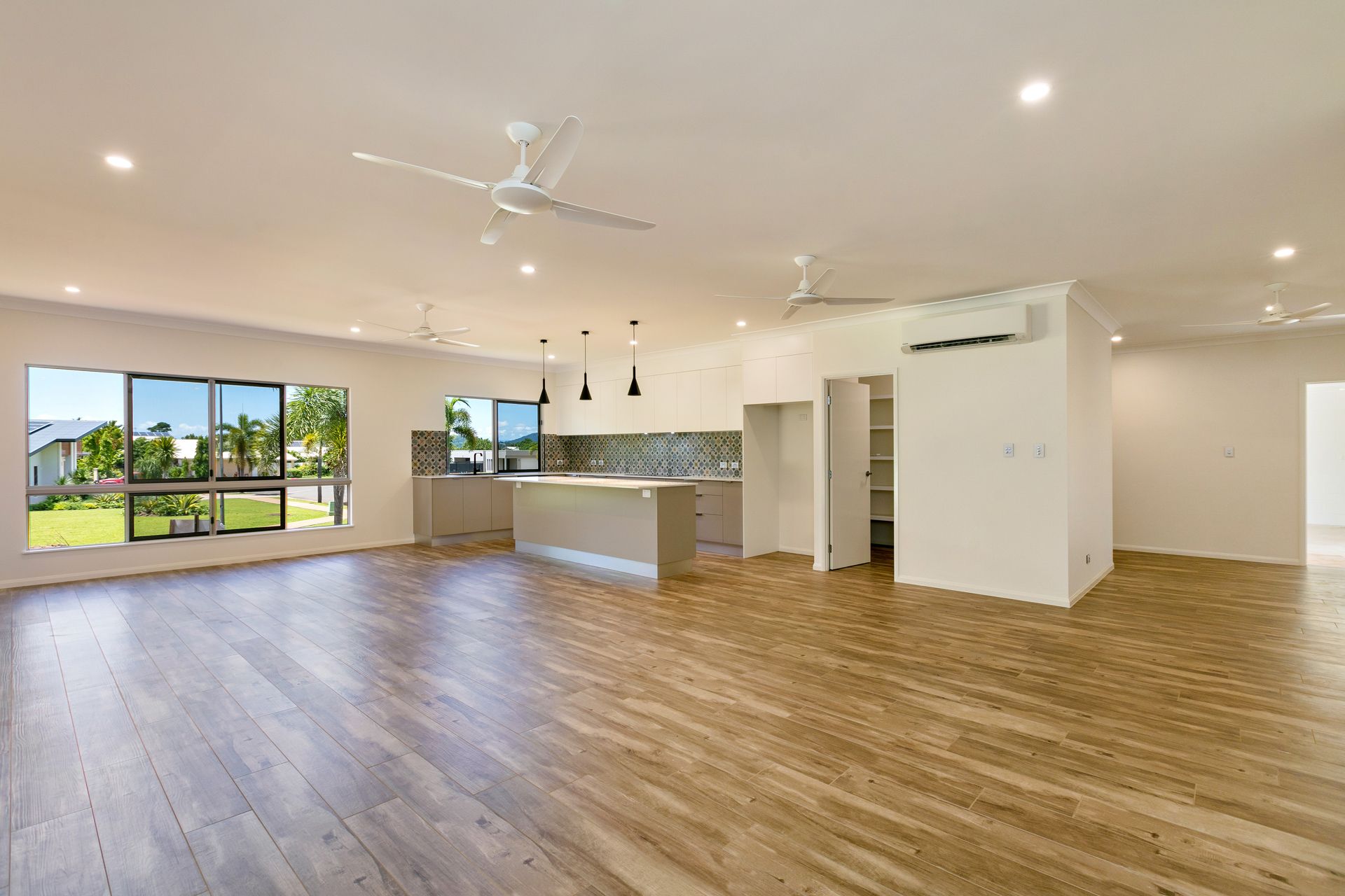 An Open-plan Living Room With Wood-look Floors — Ashlee Jones Homes in Gordonvale, QLD