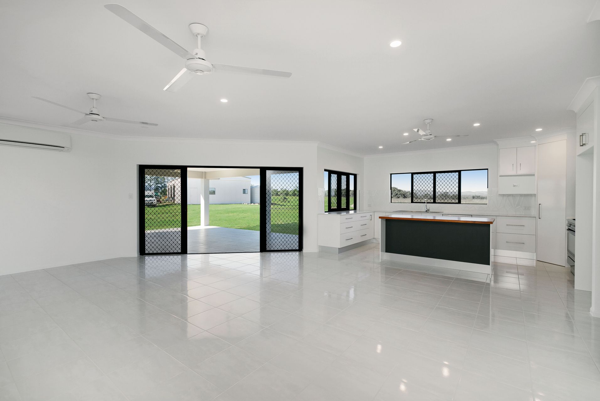 An Open-plan Living and Kitchen Area With White Walls — Ashlee Jones Homes in Gordonvale, QLD
