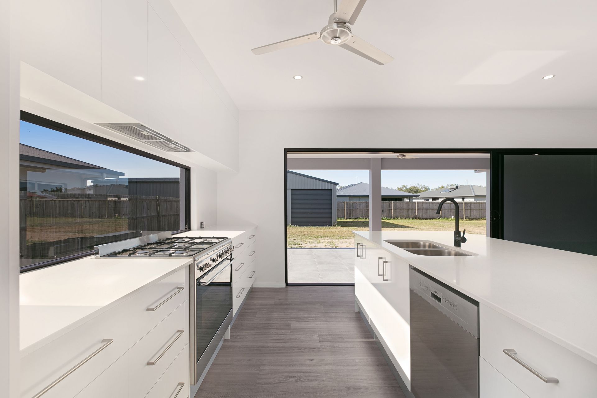 A Modern, Minimalist White Kitchen With a Long Island — Ashlee Jones Homes in Gordonvale, QLD