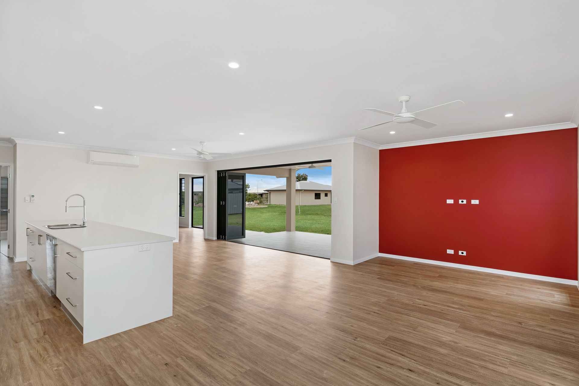A Spacious Open-plan Kitchen and Living Area With Wood Floors — Ashlee Jones Homes in Gordonvale, QLD