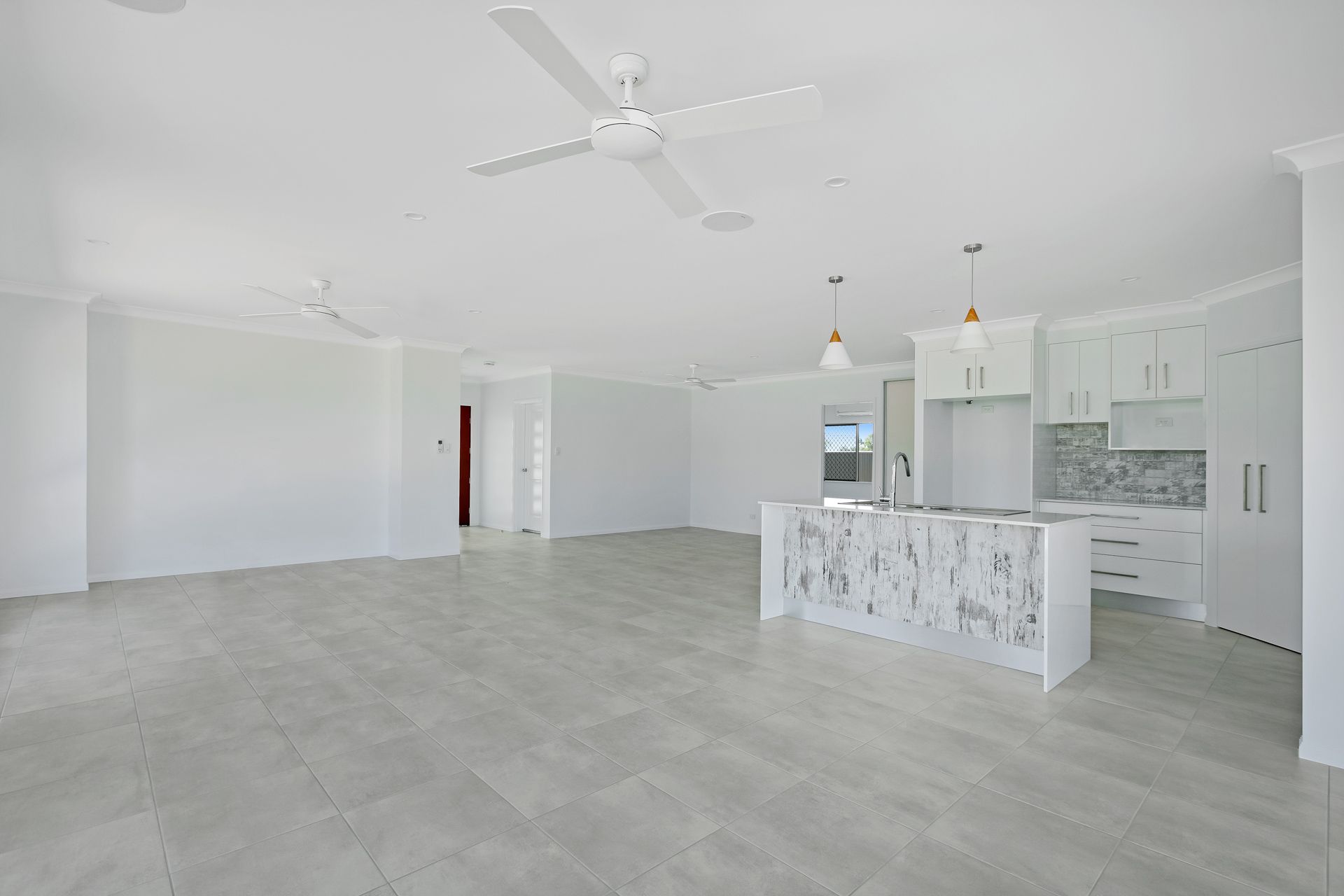 A Bright, Open-plan Kitchen and Living Area With White Walls — Ashlee Jones Homes in Gordonvale, QLD