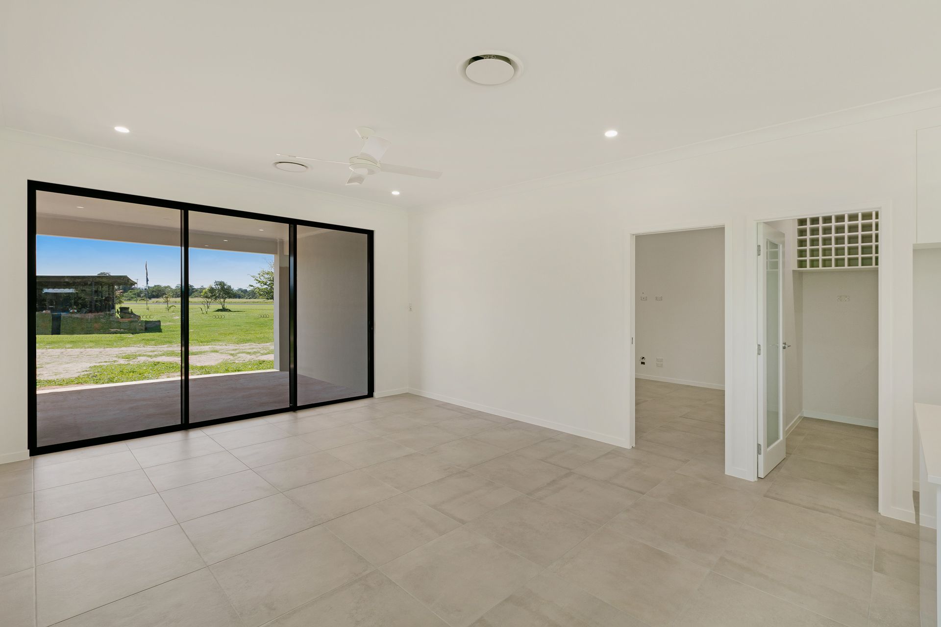 A Bright, Open-plan Living Space With Light Tile Flooring — Ashlee Jones Homes in Gordonvale, QLD