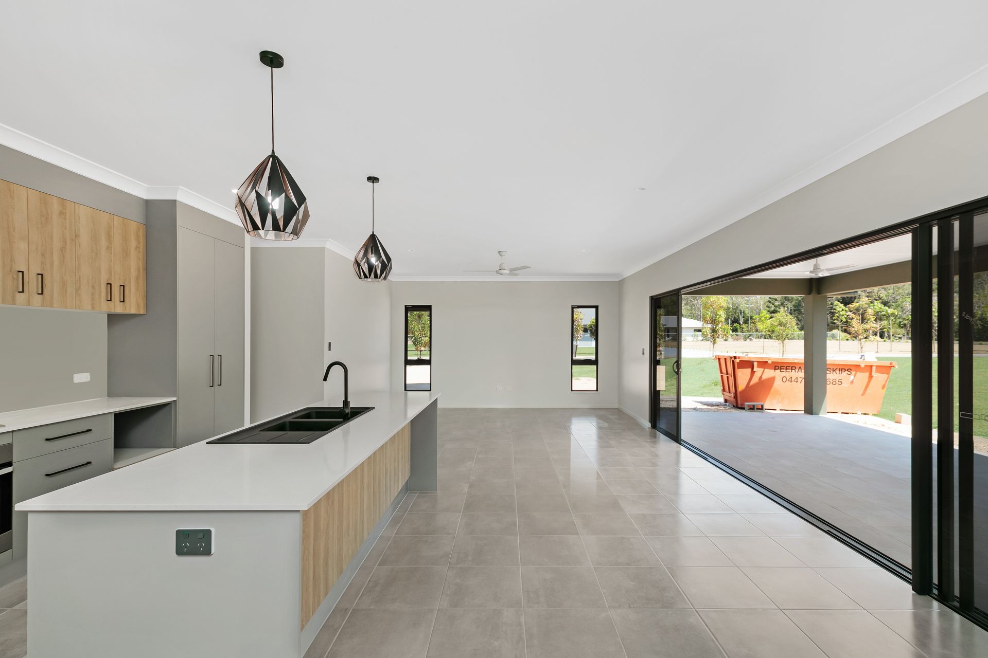 A Modern Open-plan Kitchen With a White Island Bench — Ashlee Jones Homes in Gordonvale, QLD