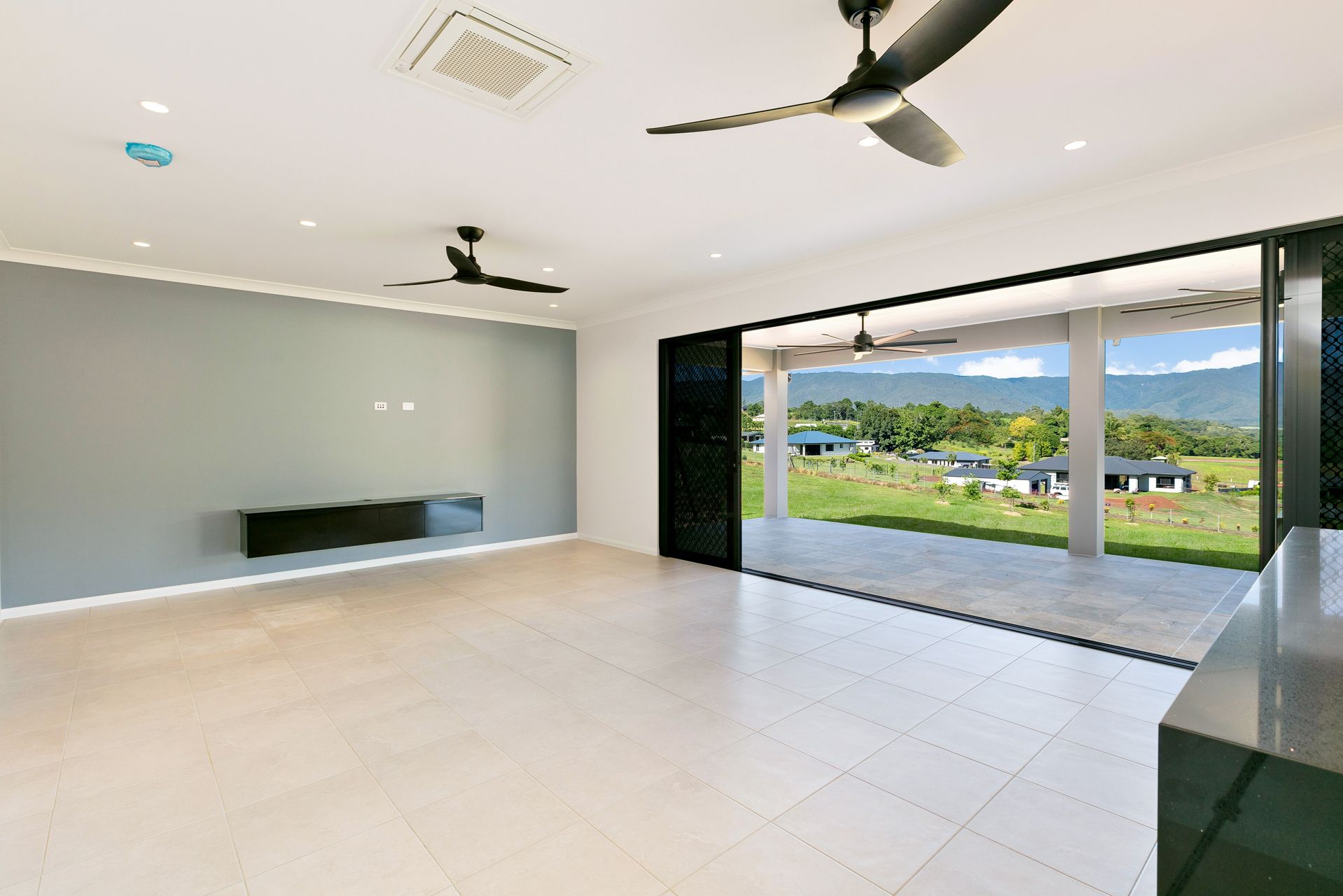 An Open-plan Room With Light Tile Floors — Ashlee Jones Homes in Gordonvale, QLD