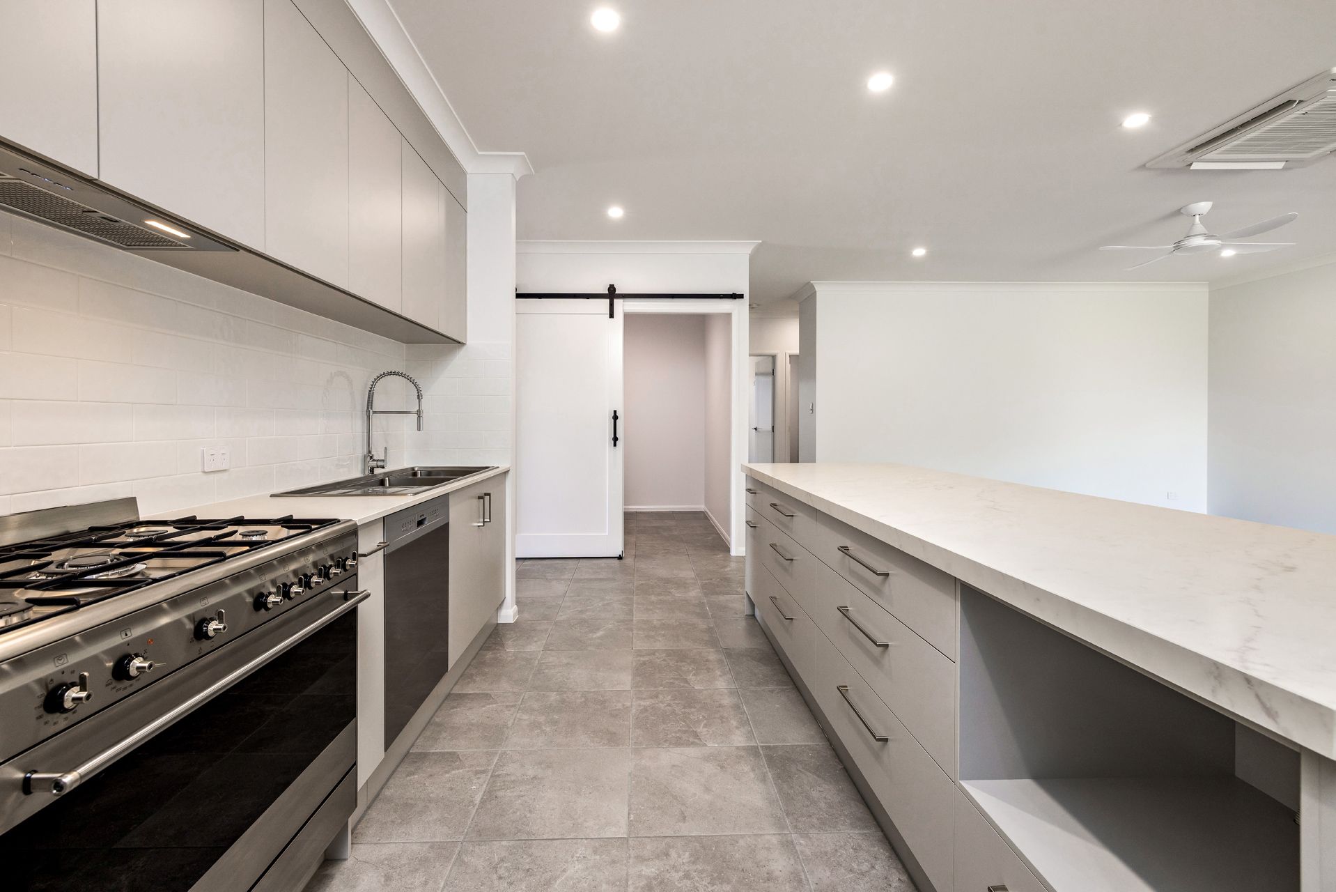Modern Kitchen Featuring a Large Island, Stainless Steel Stove — Ashlee Jones Homes in Gordonvale, QLD