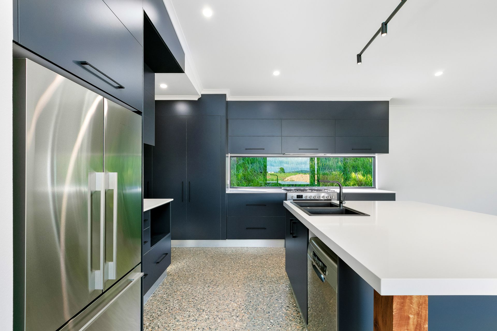 Modern Kitchen With Dark Cabinetry, White Countertops — Ashlee Jones Homes in Gordonvale, QLD