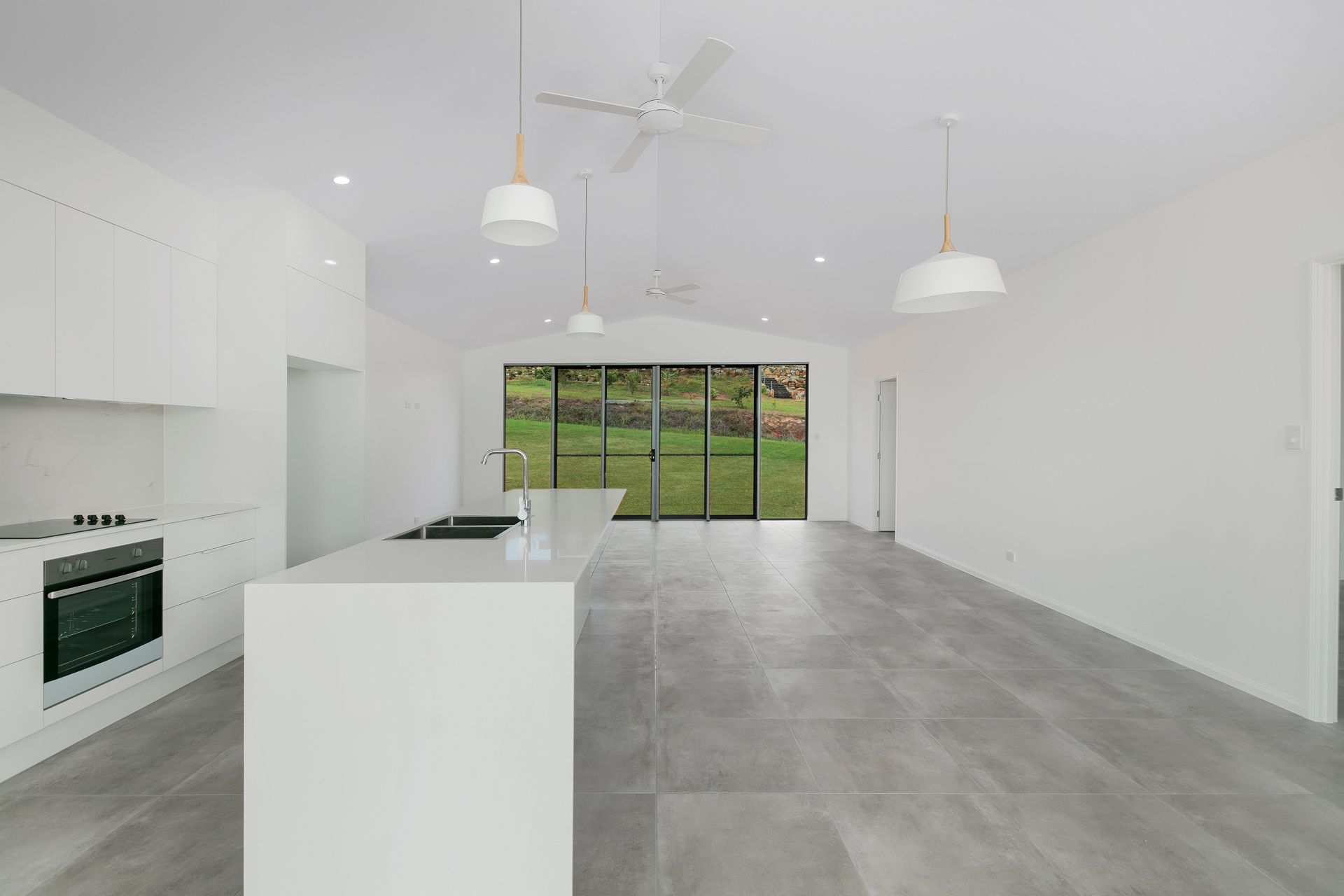 Modern, Minimalist White Kitchen and Open-plan Living Area — Ashlee Jones Homes in Gordonvale, QLD