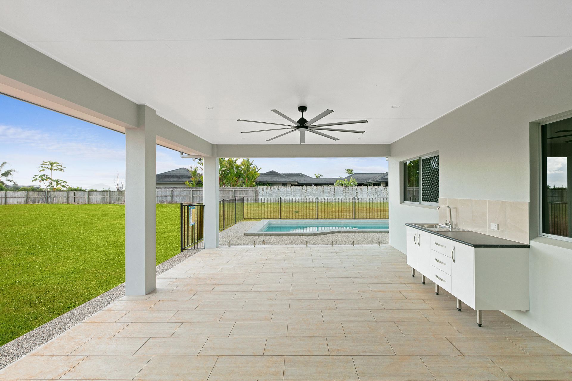 A Covered Outdoor Patio Featuring a Ceiling Fan, a Kitchen Cabinet — Ashlee Jones Homes in Gordonvale, QLD