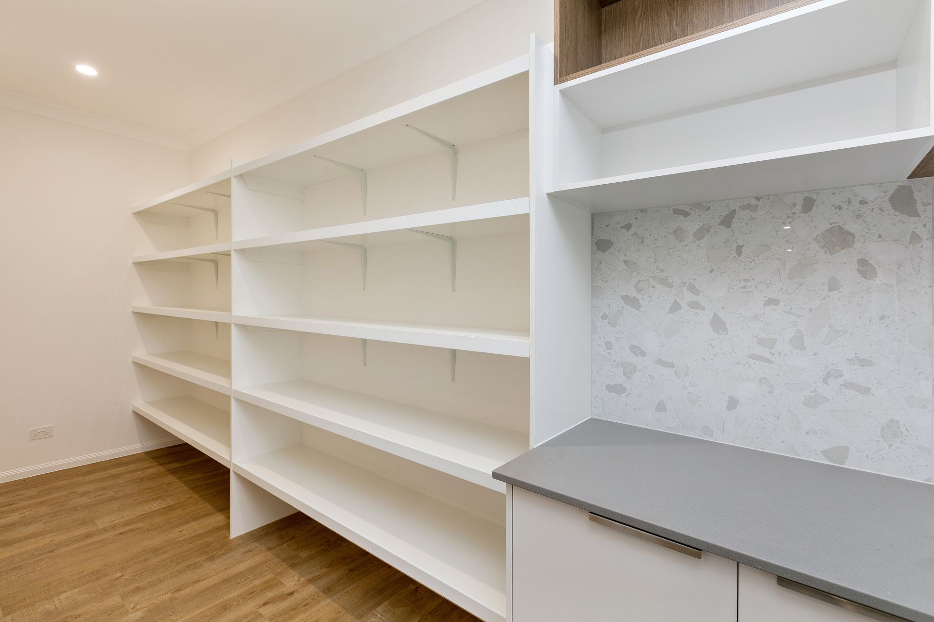 A Walk-in Pantry Featuring White Shelving, Light Wood Flooring — Ashlee Jones Homes in Gordonvale, QLD