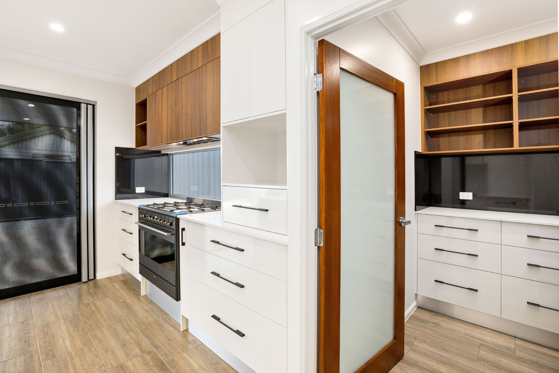 A Modern Kitchen Featuring White Cabinets — Ashlee Jones Homes in Gordonvale, QLD