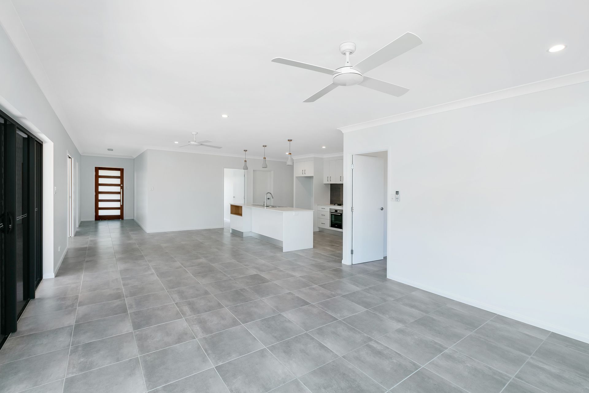 An Open-plan Living and Kitchen Area With White Walls — Ashlee Jones Homes in Gordonvale, QLD