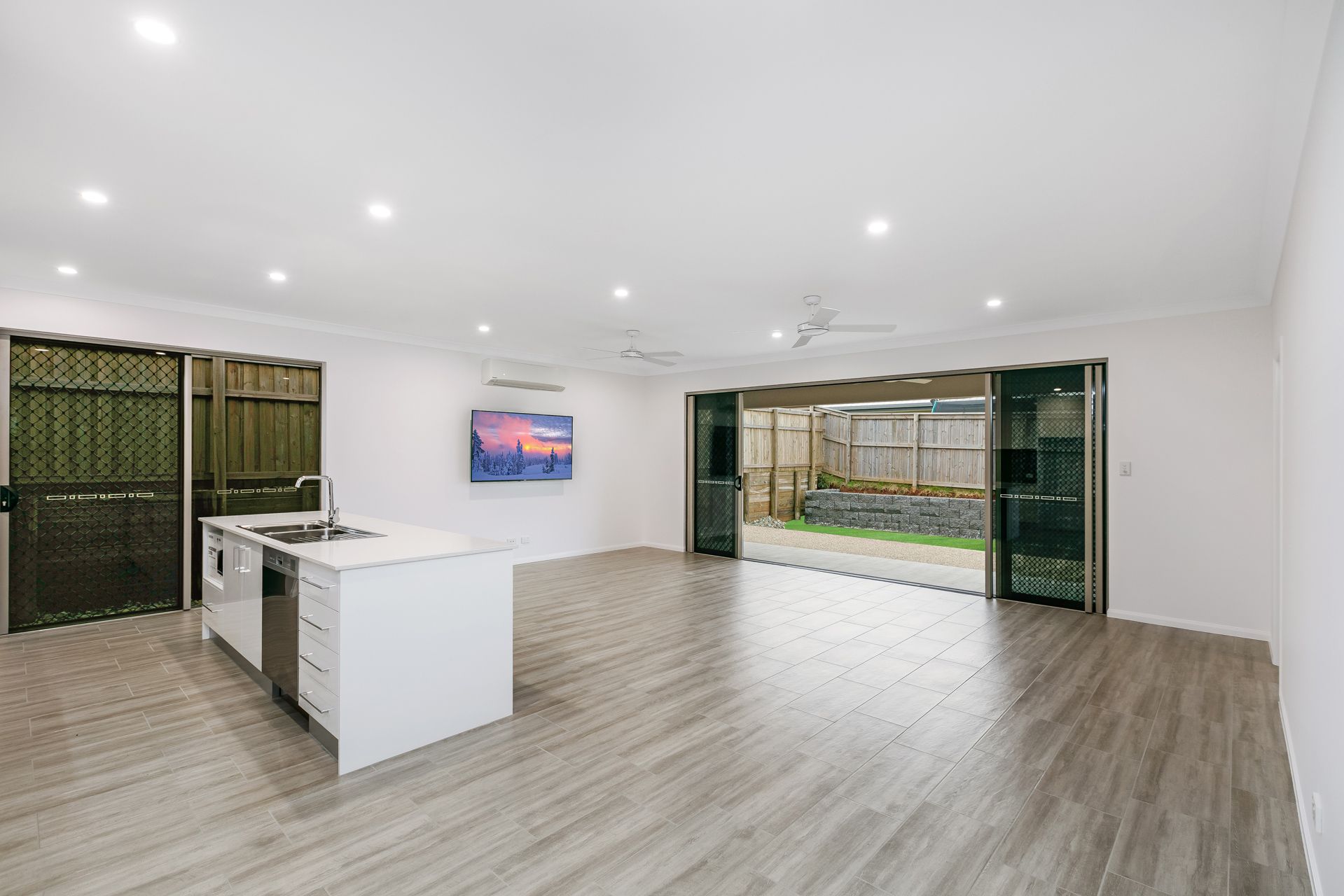 Modern, Open-plan Kitchen and Living Space With White Walls — Ashlee Jones Homes in Gordonvale, QLD